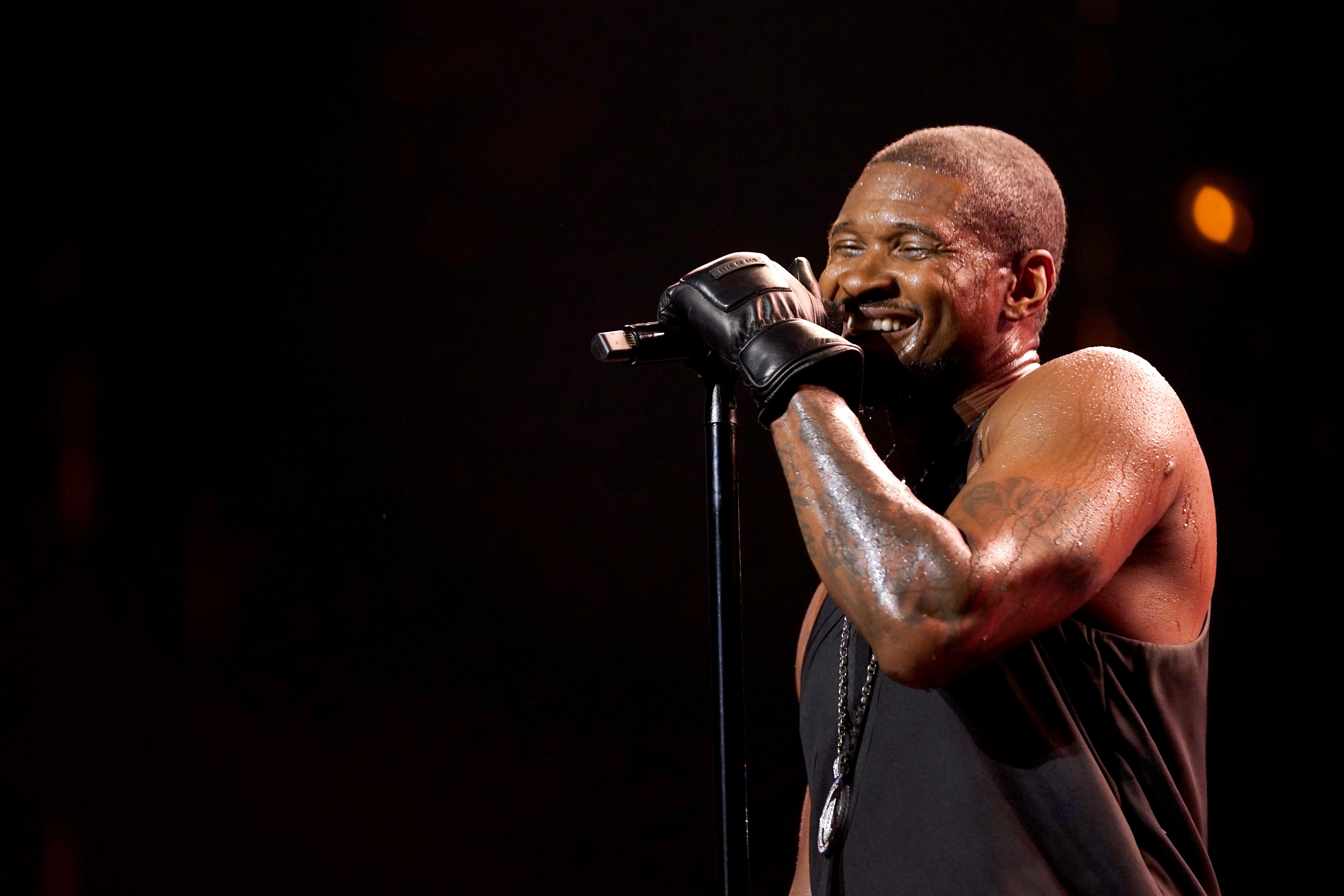 Photo shows Usher with a mic.