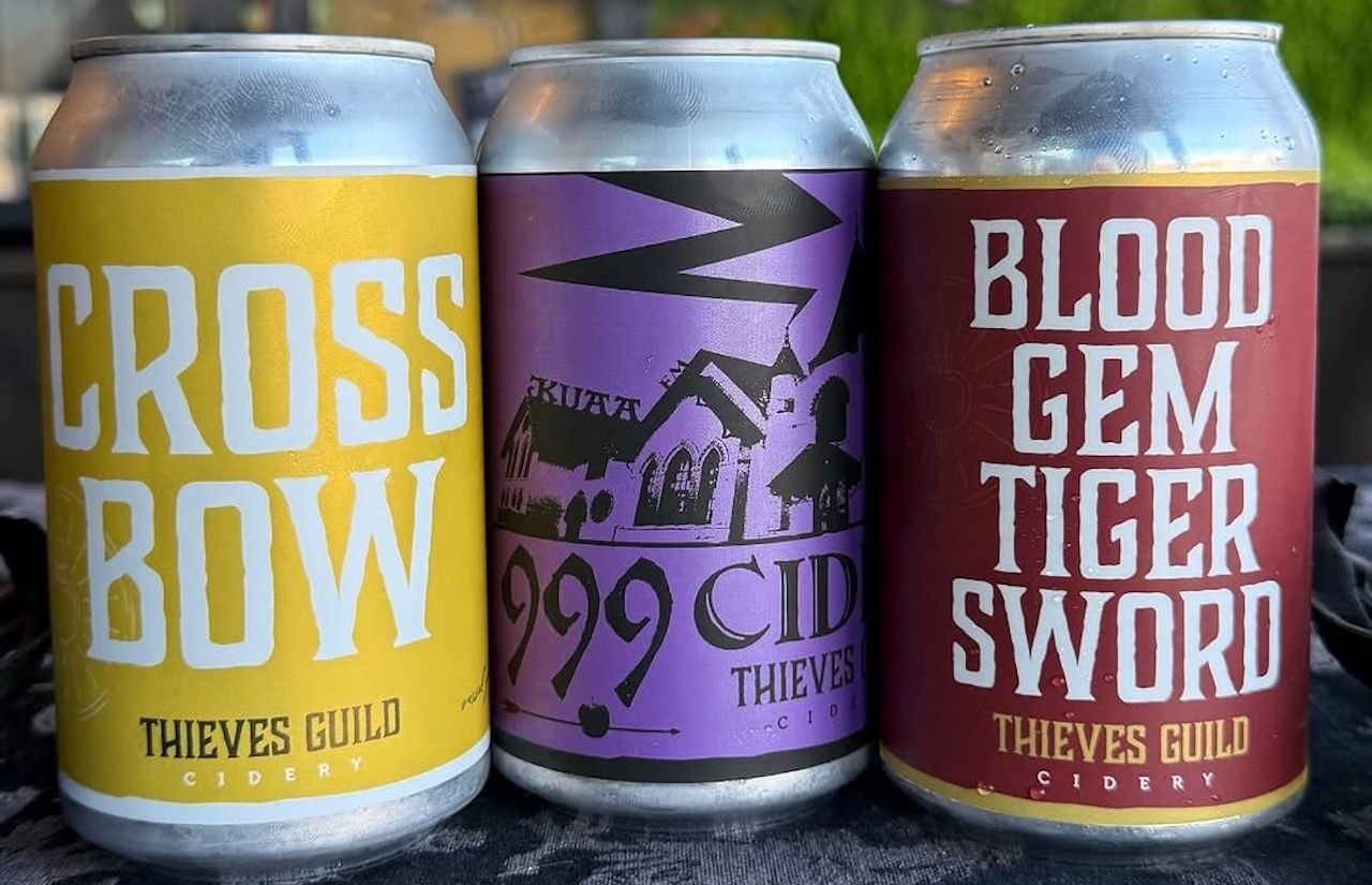 Three beverage cans with labels that say Cross Bow 999 Cider and Blood Gem Tiger Sword