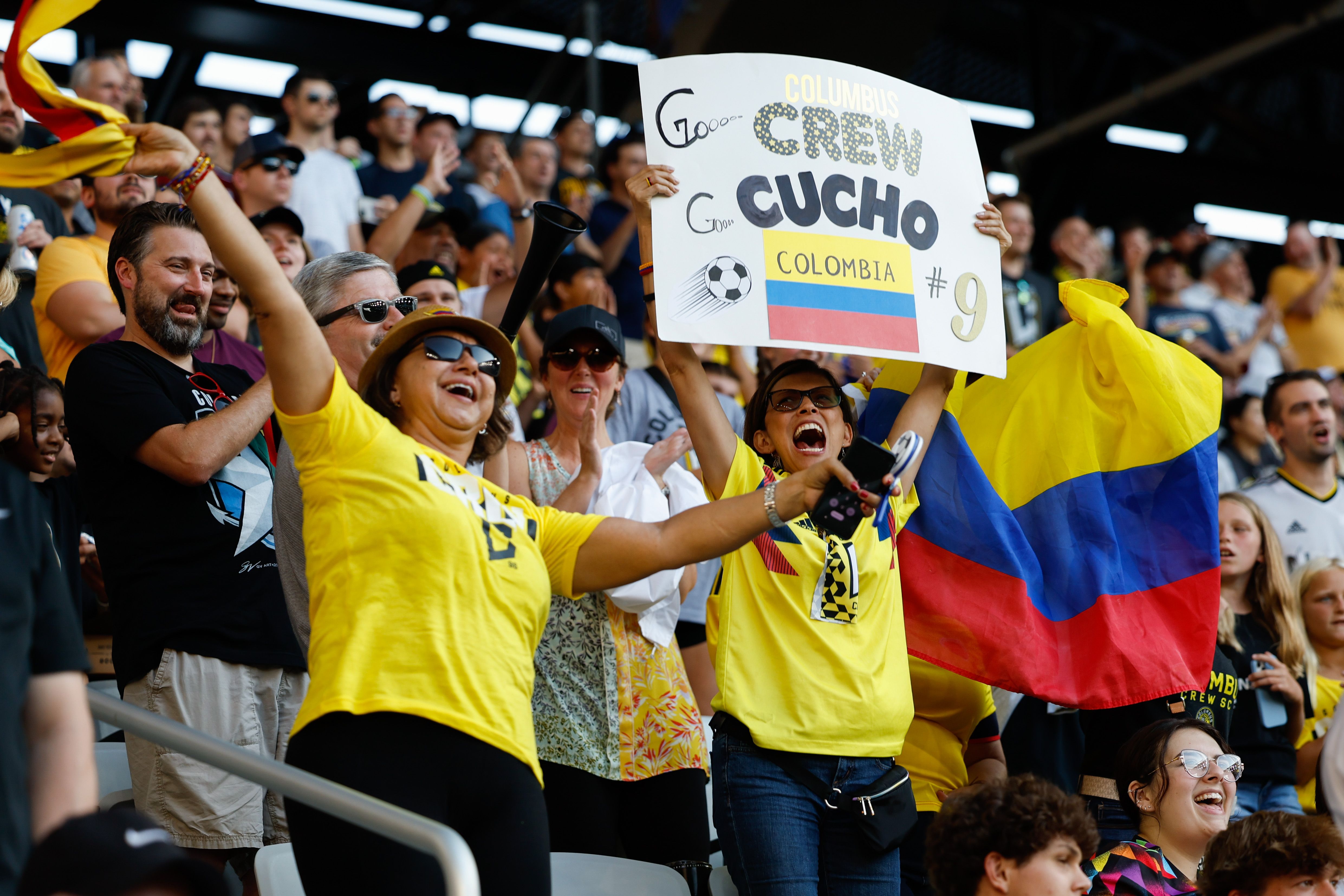Columbus Crew fans hold up a sign reading "Crew Cucho Colombia" with a Colombian flag. 