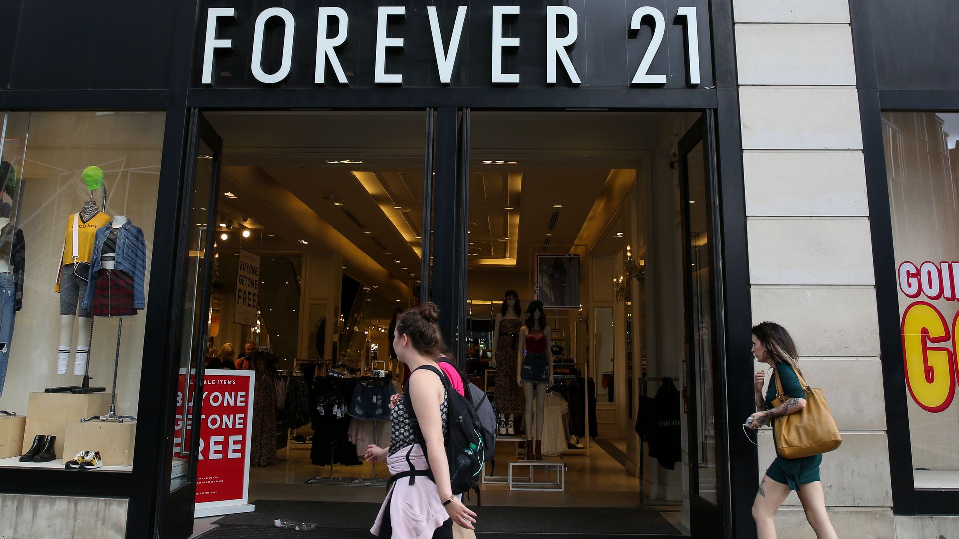 Shoppers walk past a branch of Forever 21 store in central London.
