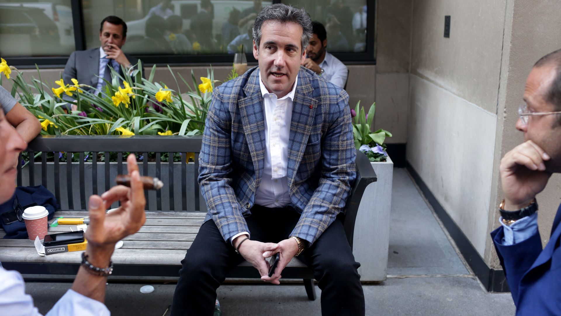 Michael Cohen sitting on a bench, talking