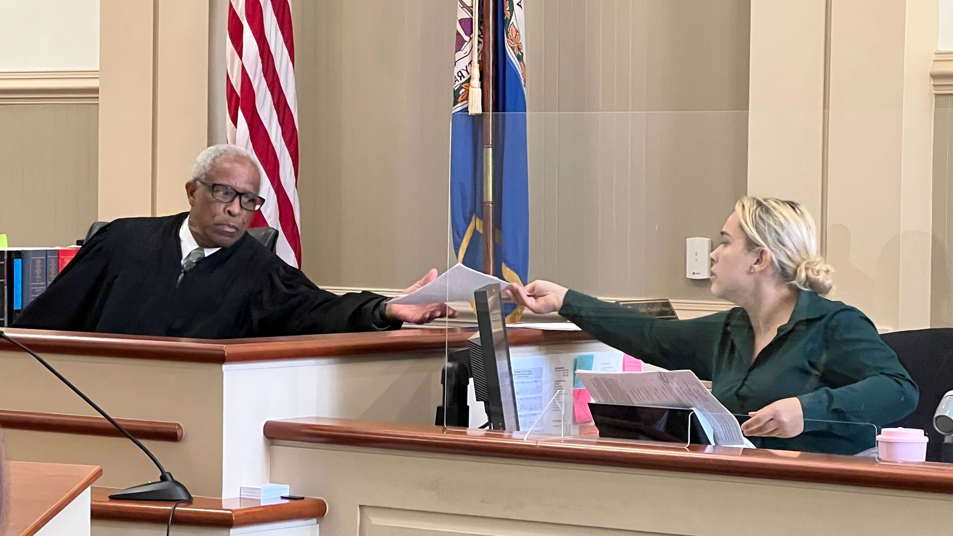 Judge David Hicks passes a piece of paper to his court