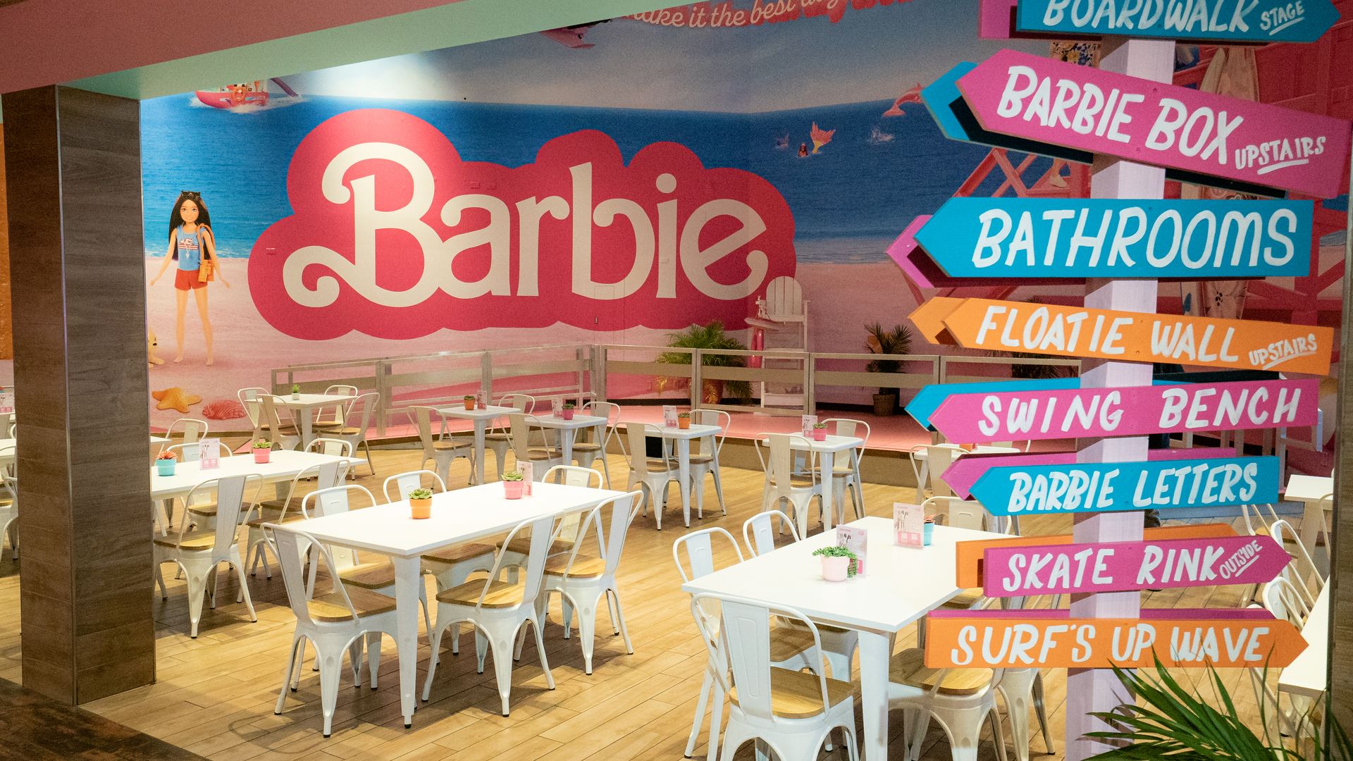 A photo shows pastel-colored signs with Barbie themes