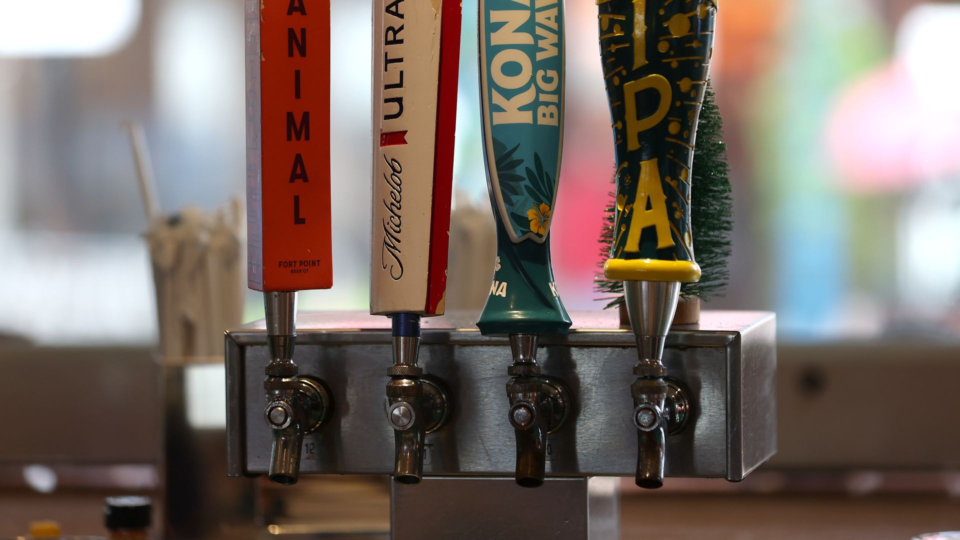 Photo of four tap handles for different beers at a bar