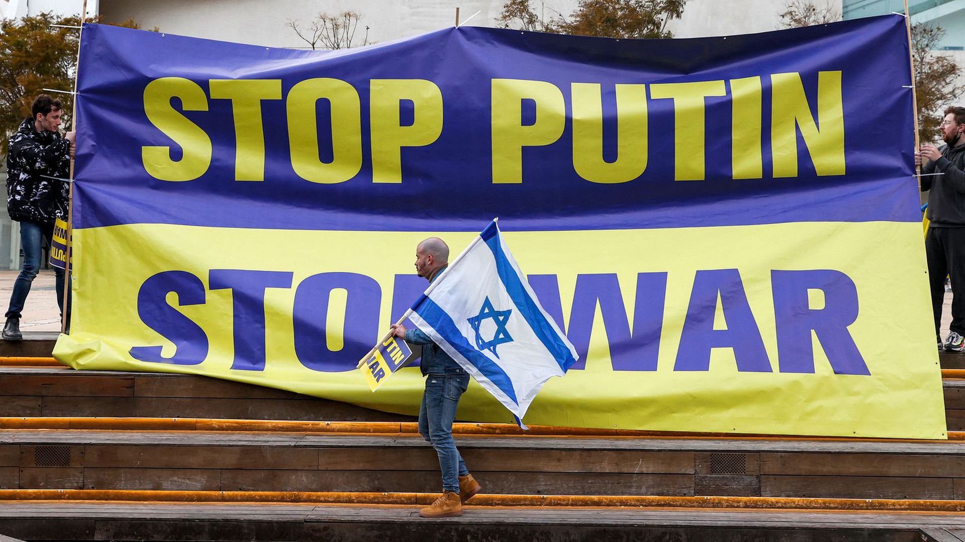 A Tel Aviv demonstrator holds an Israeli flag on March 20 during a protest against Russia's invasion of Ukraine. Photo: Jack Guez/AFP via Getty Images