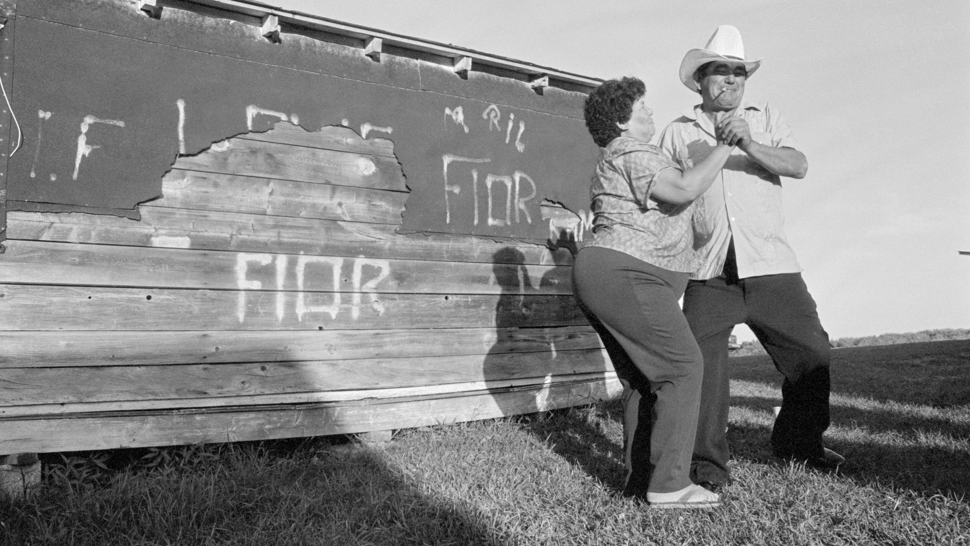 A migrant Latino farm worker dances with his wife. He and his family are living in southwest Michigan during the summer harvest season.