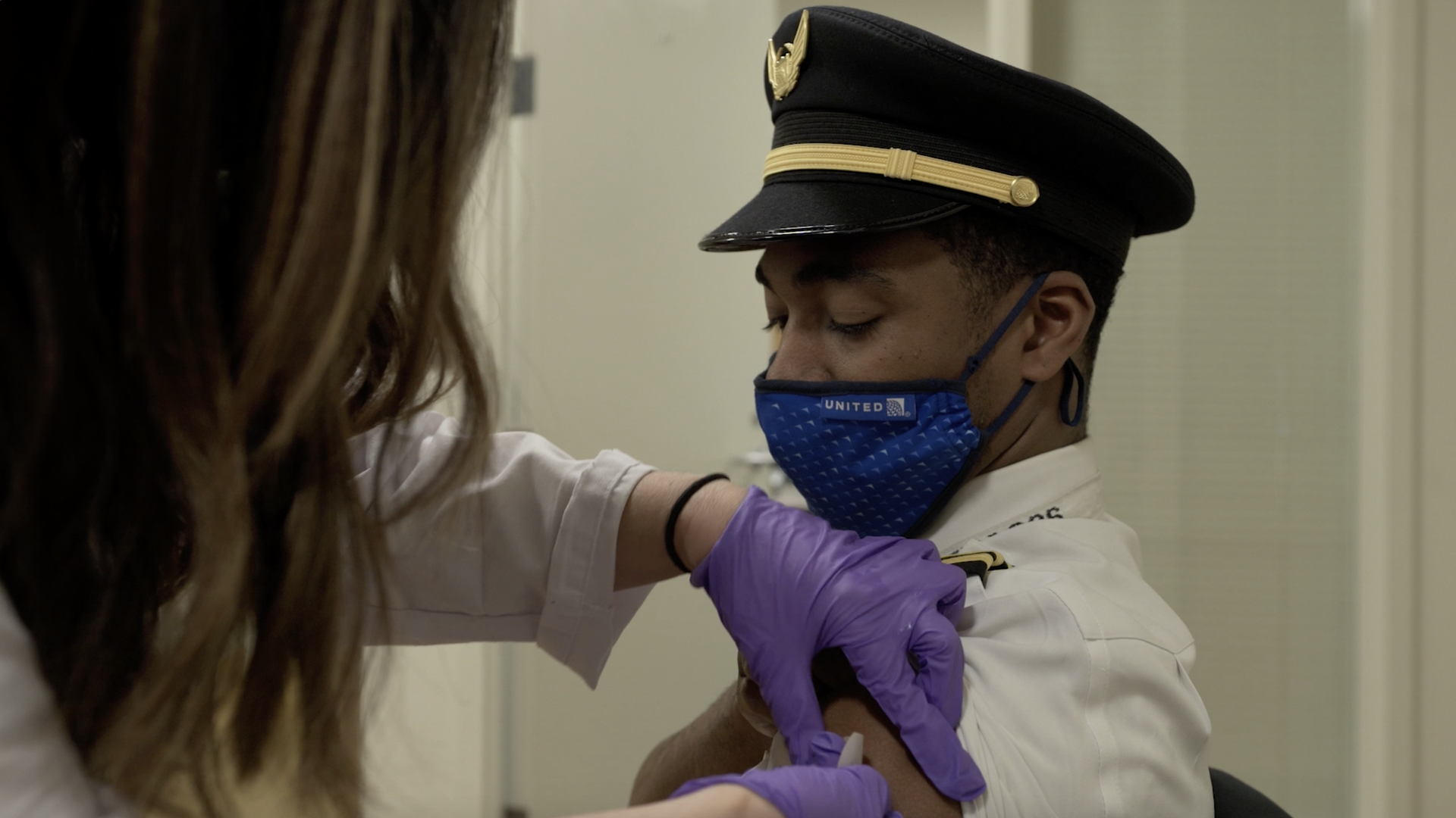 A united airlines pilot being vaccinated.