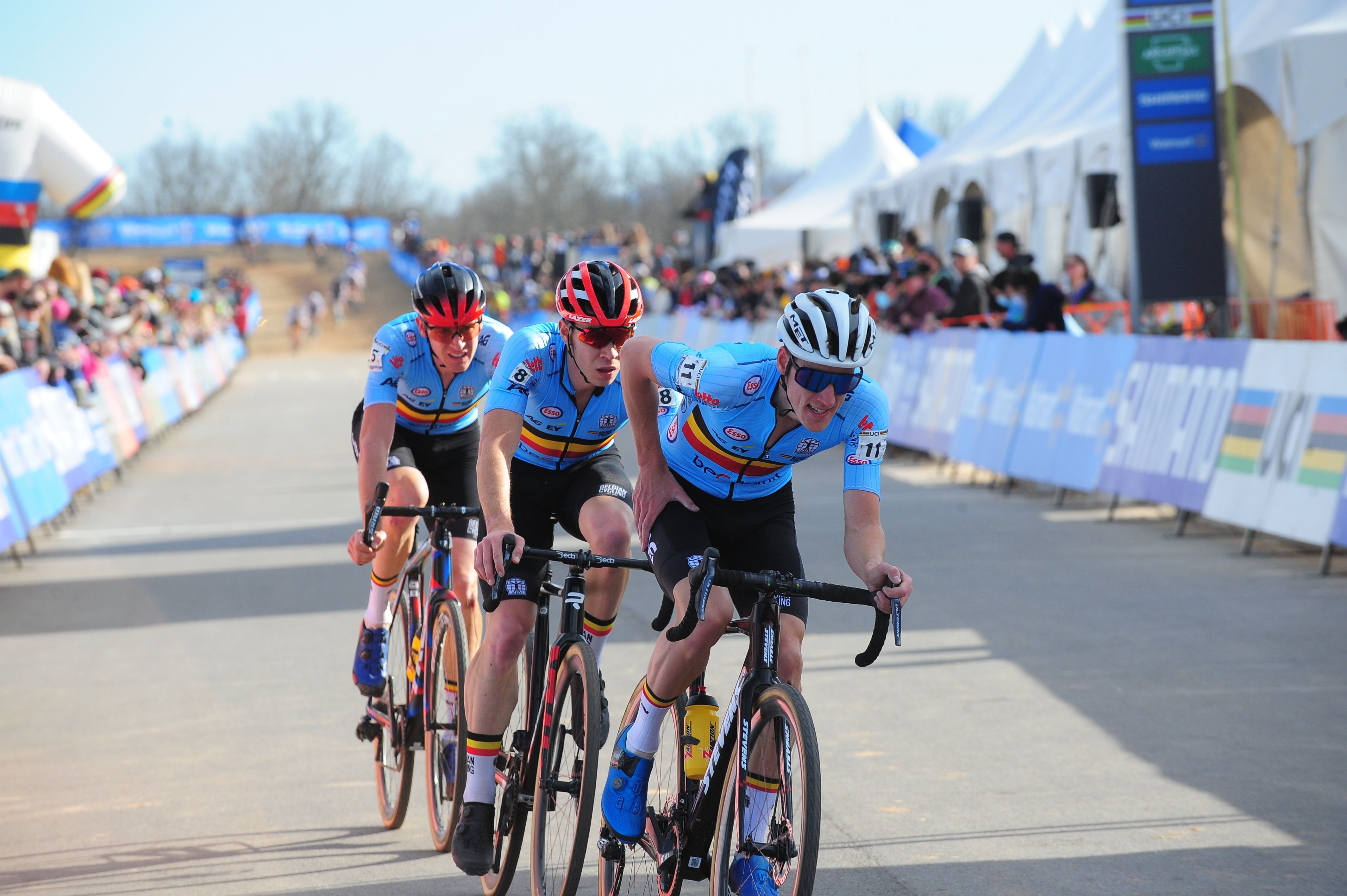 Three cyclists compete in the elite men's category at a cyclo-cross event. 