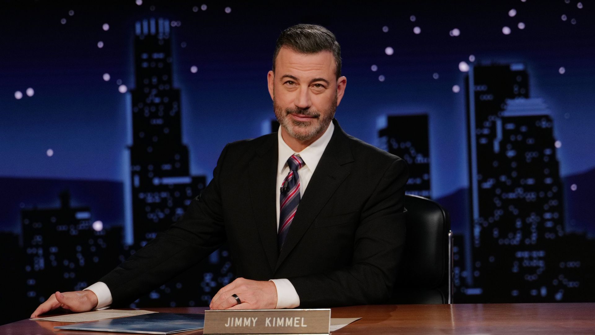 Jimmy Kimmel sitting at a desk 