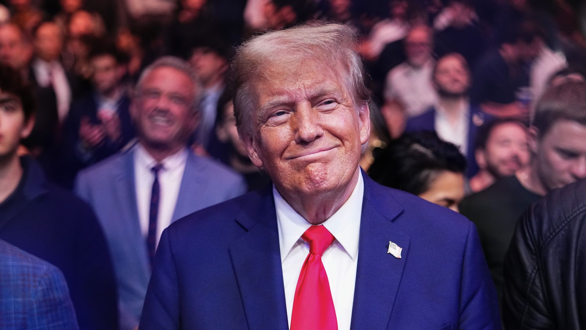 Donald Trump smiling ringside in blue suit, red tie