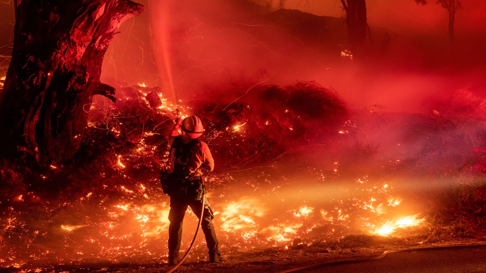 A firefighter douses flames from a backfire during the Maria fire in Santa Paula, California on November 1