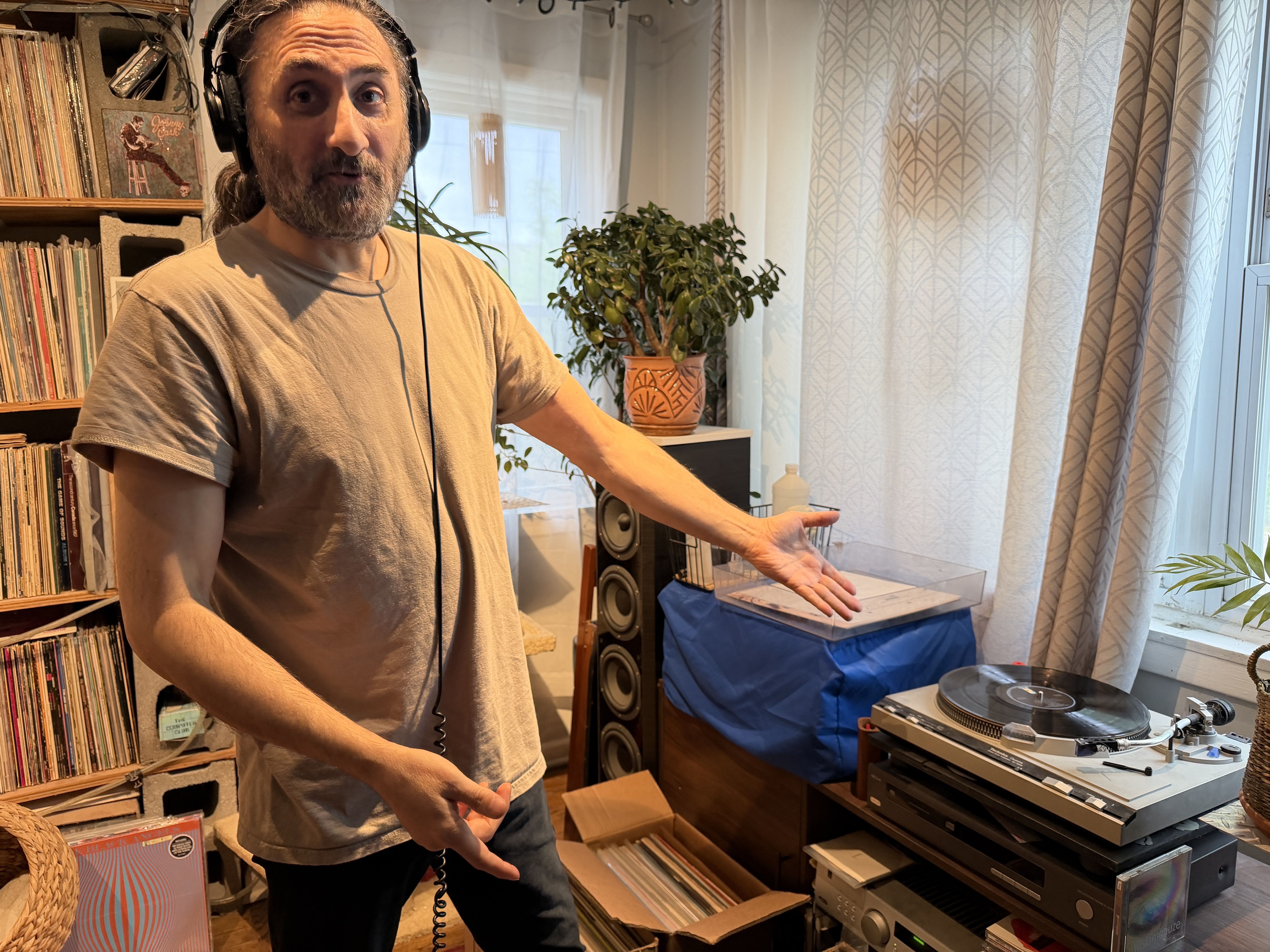 man with headphones on next to a record player