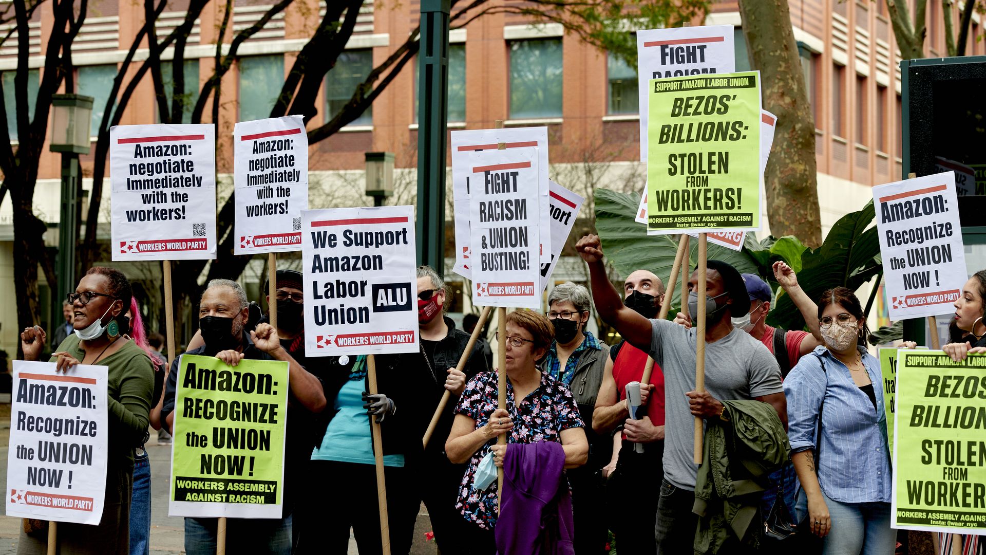 Photo of people holding signs that call for unionizing against Amazon