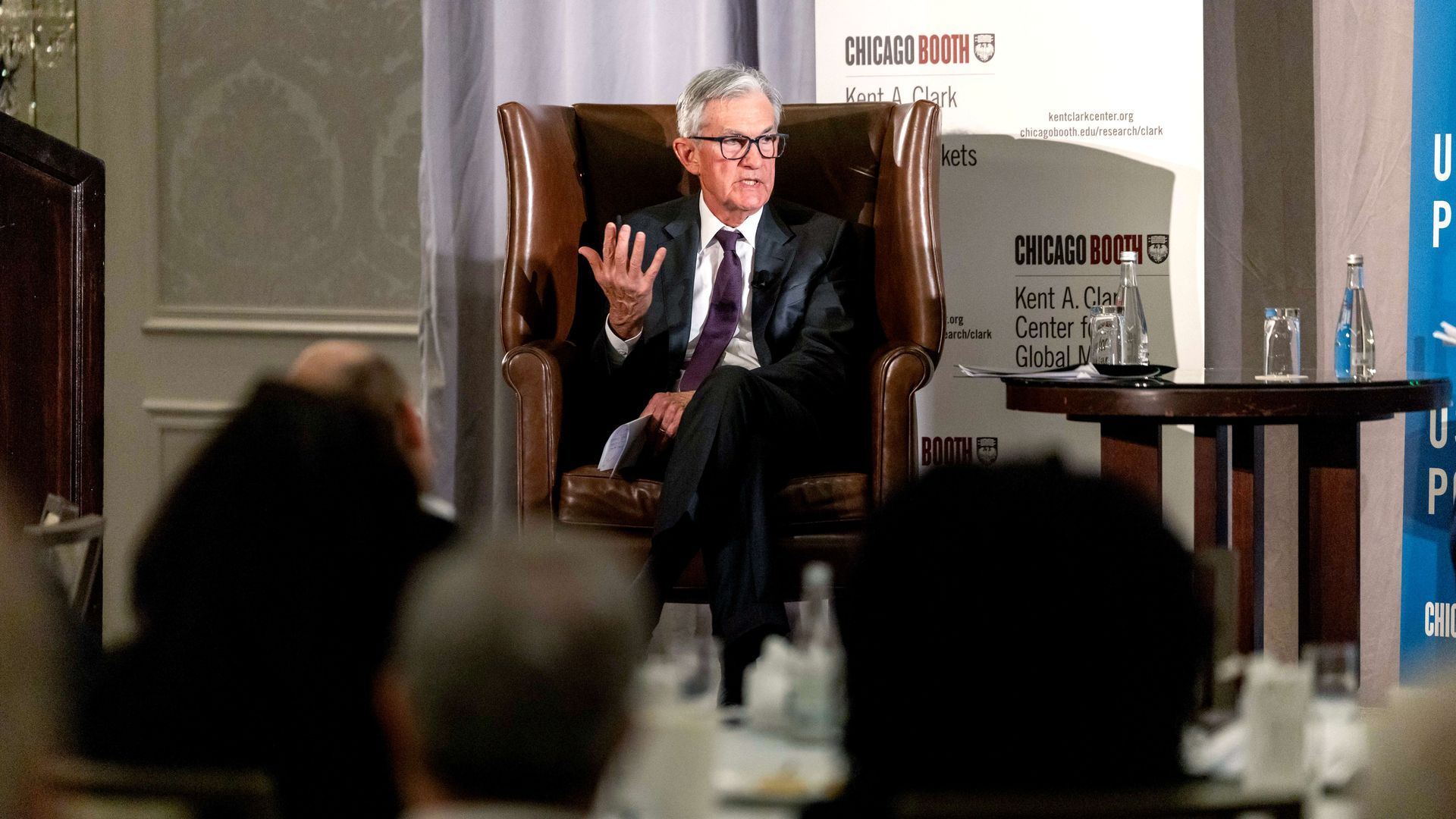 Fed chair Jerome Powell, seated in a chair, speaks during an event.