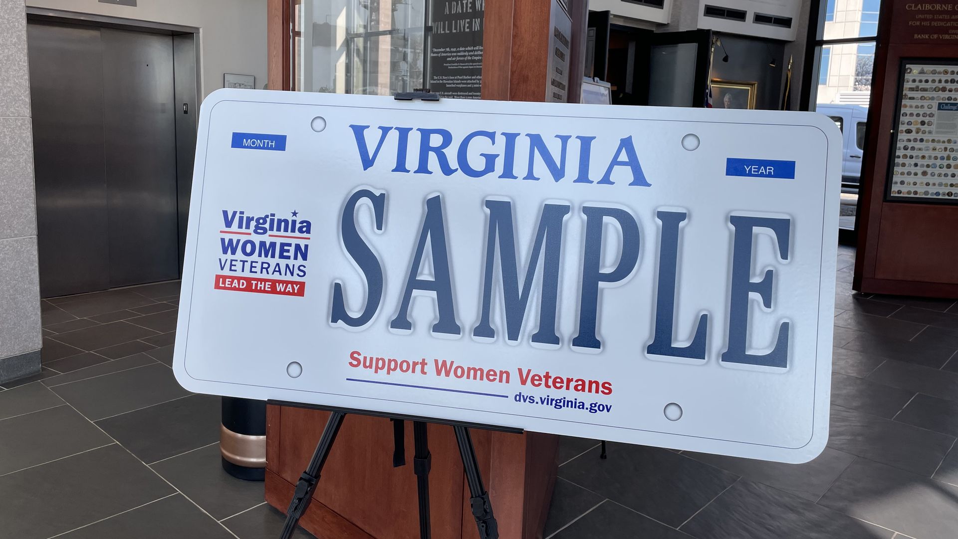 A picture of a giant Virginia license plate that says "SAMPLE" and "Virginia Women Veterans Lead the Way" in red and blue on the left side and "Support Women Veterans" underneath the "SAMPLE"