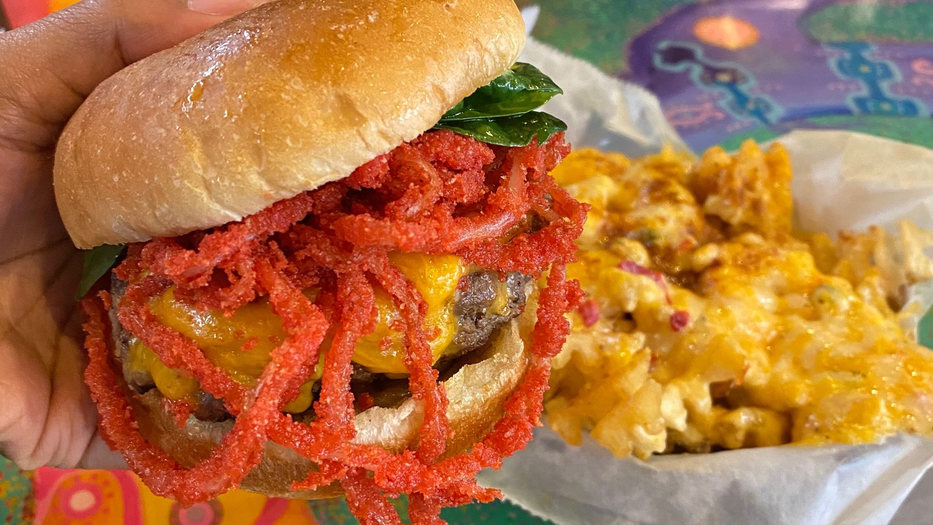 burger with hot Cheetos on it and fries in the background