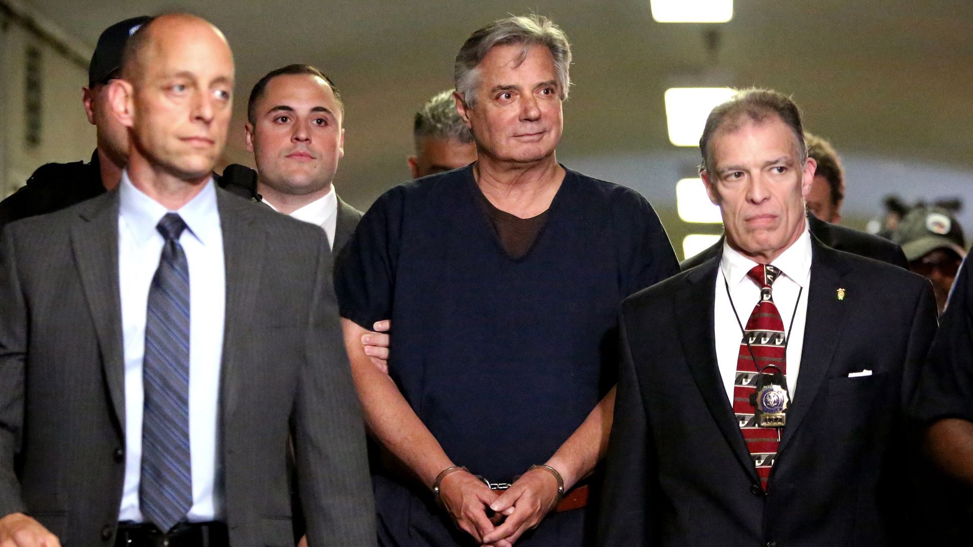 Paul Manafort being escorted out of a courtroom in a jumpsuit.