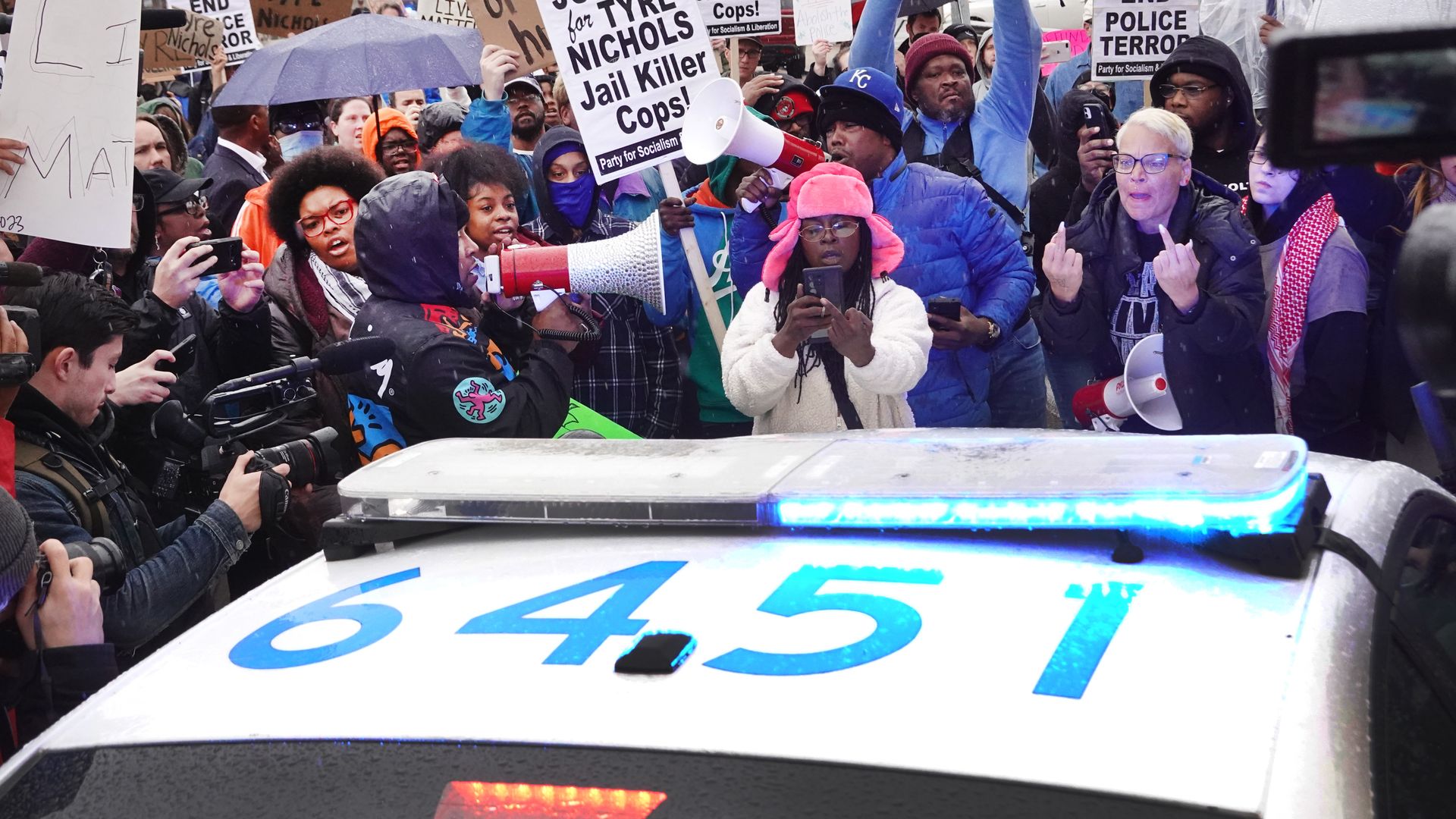 People protesting the police beating of Tyre Nichols near a police car in Memphis in January 2023.