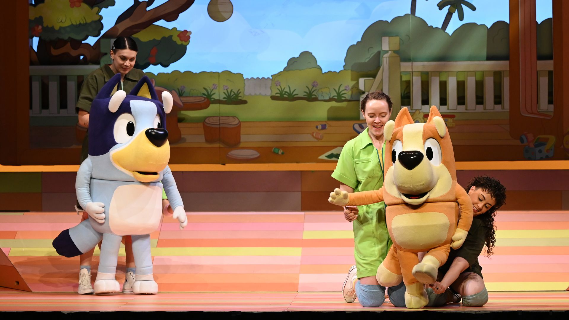 Stuffed characters from "Bluey's Big Play" perform alongside human counterparts onstage.