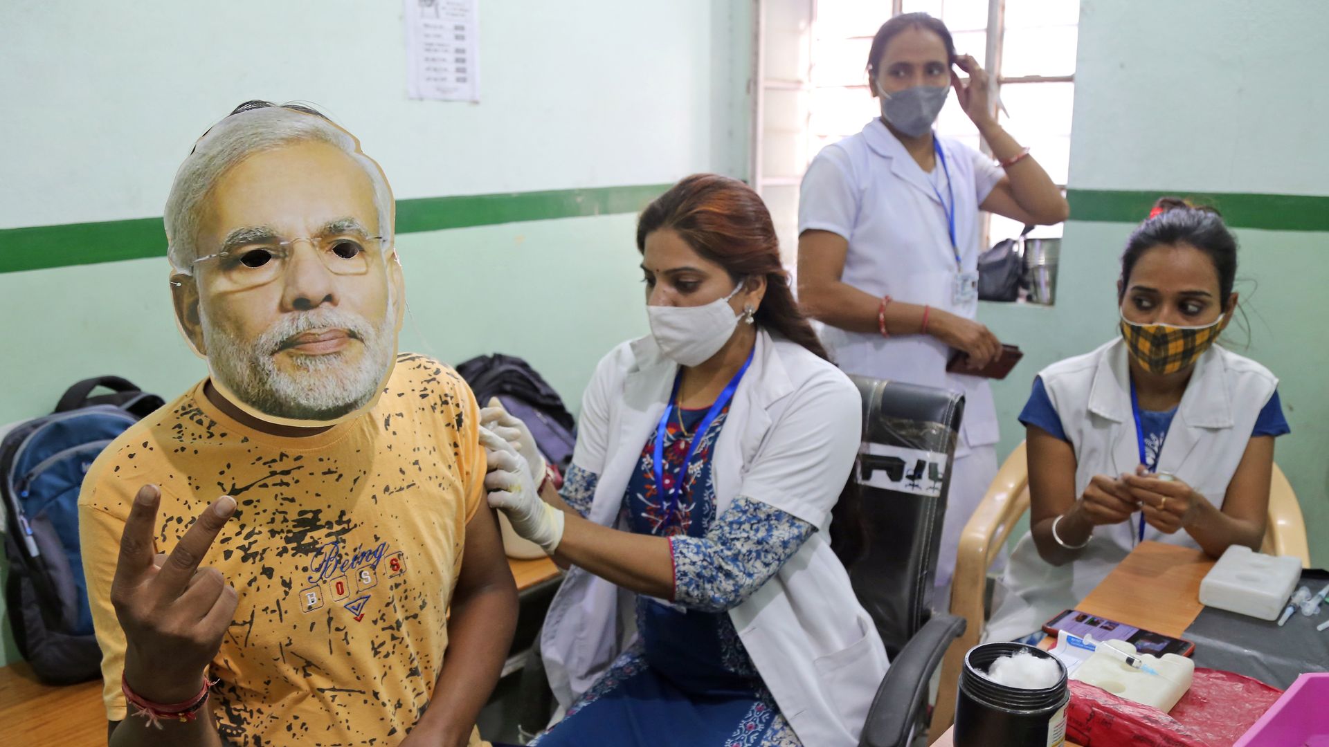  A health worker inoculates a COVID-19 vaccine dose to a beneficiary wearing face mask of Prime Minister Narendra Modi on September 17.