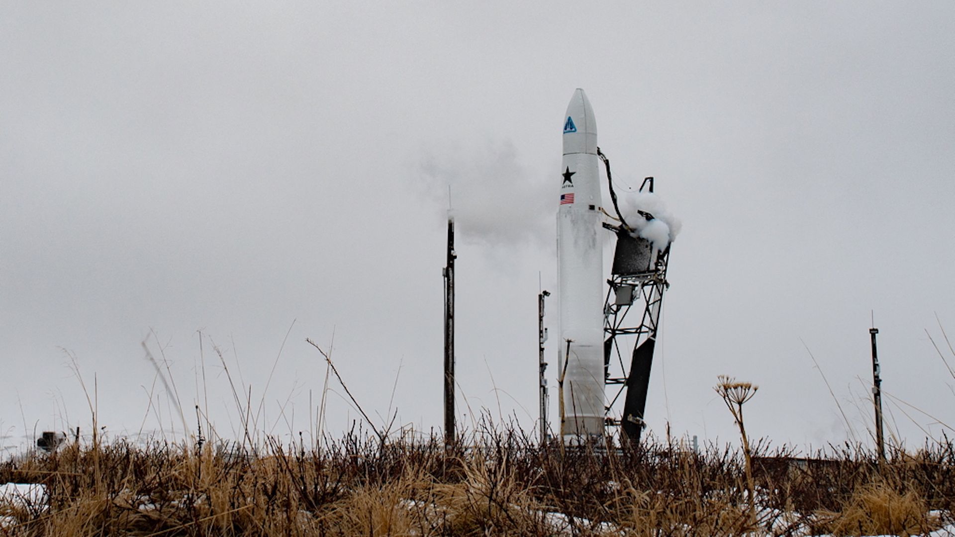 An Astra rocket stands tall against a sea of clouds in Alaska