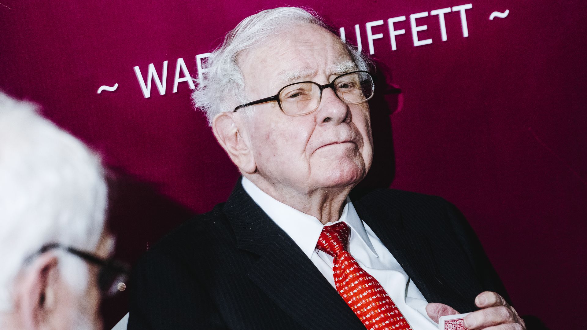 Warren Buffet sits while wearing a suit and tie 