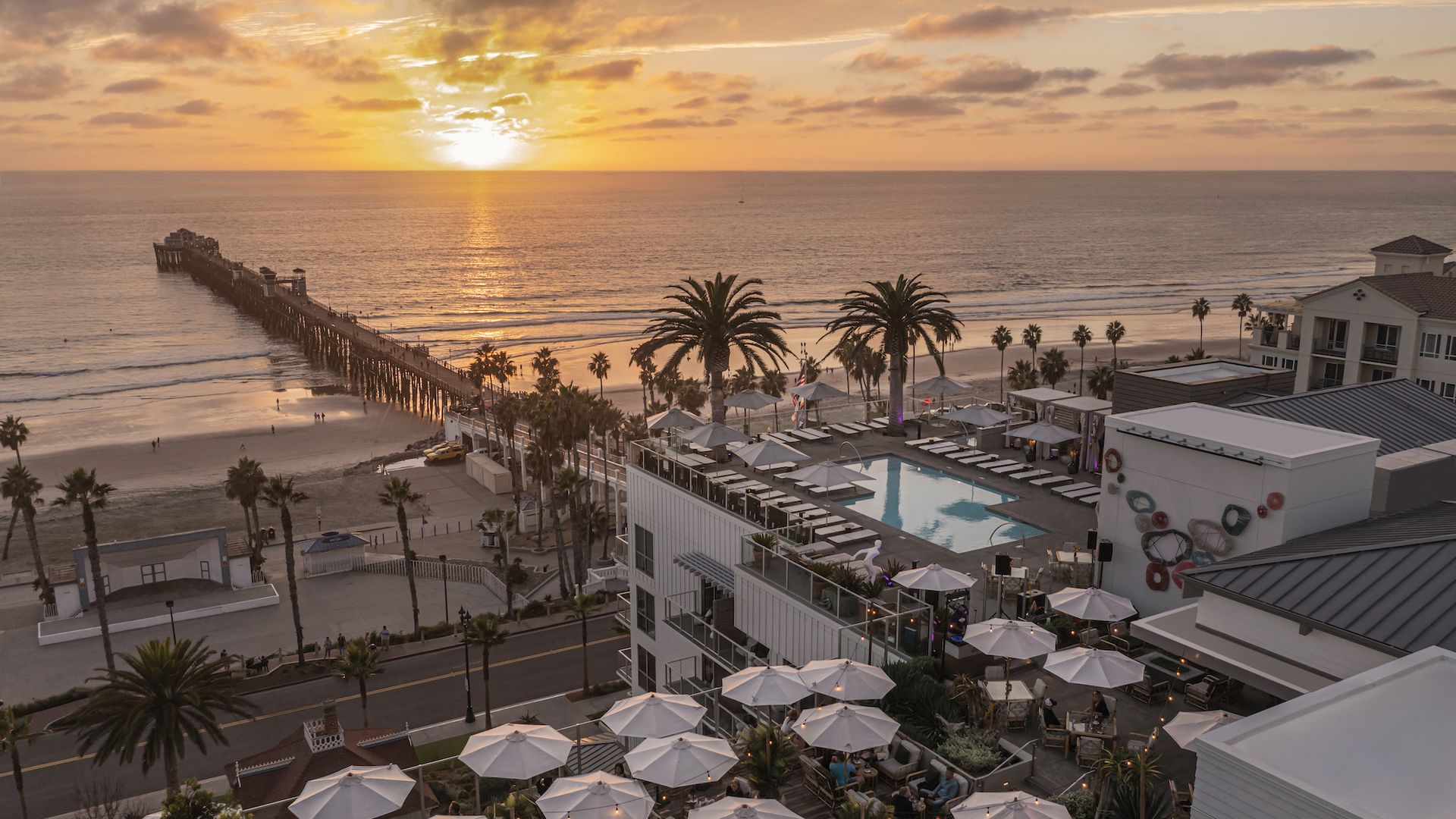 An aerial view of Mission Pacific Beach Resort at sunset with the Oceanside Pier.