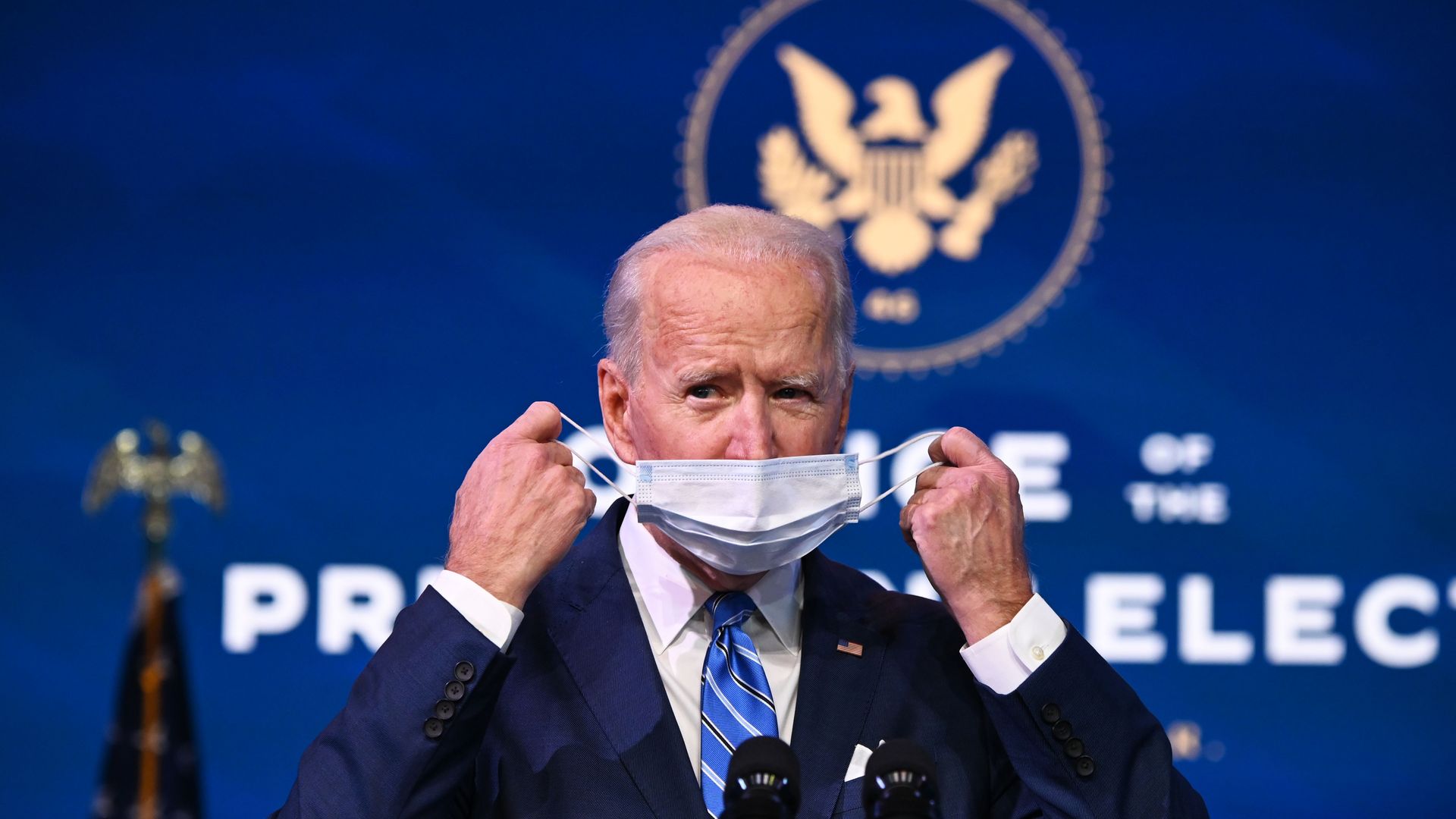 Joe Biden is seen removing a mask before outlining his program to provide COVID-19 relief.