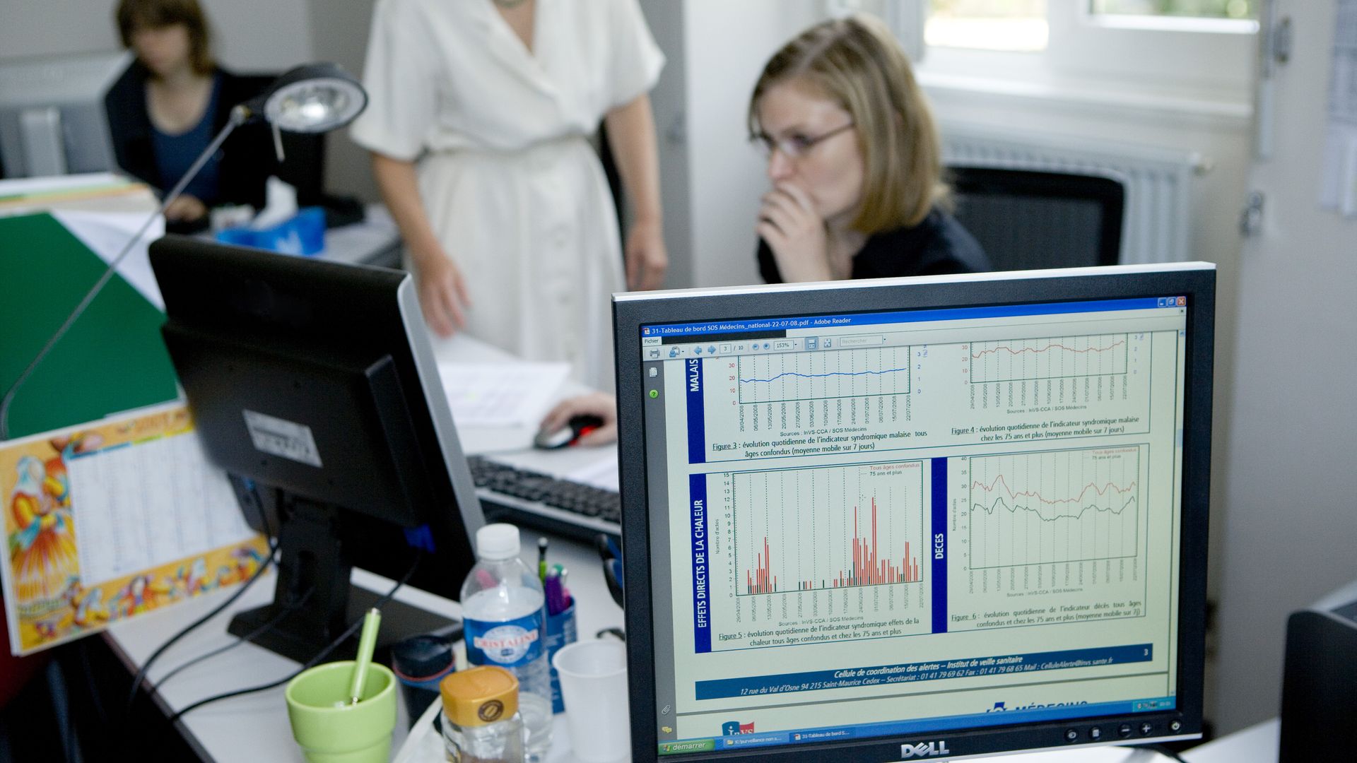 a computer on a desk showing data and charts