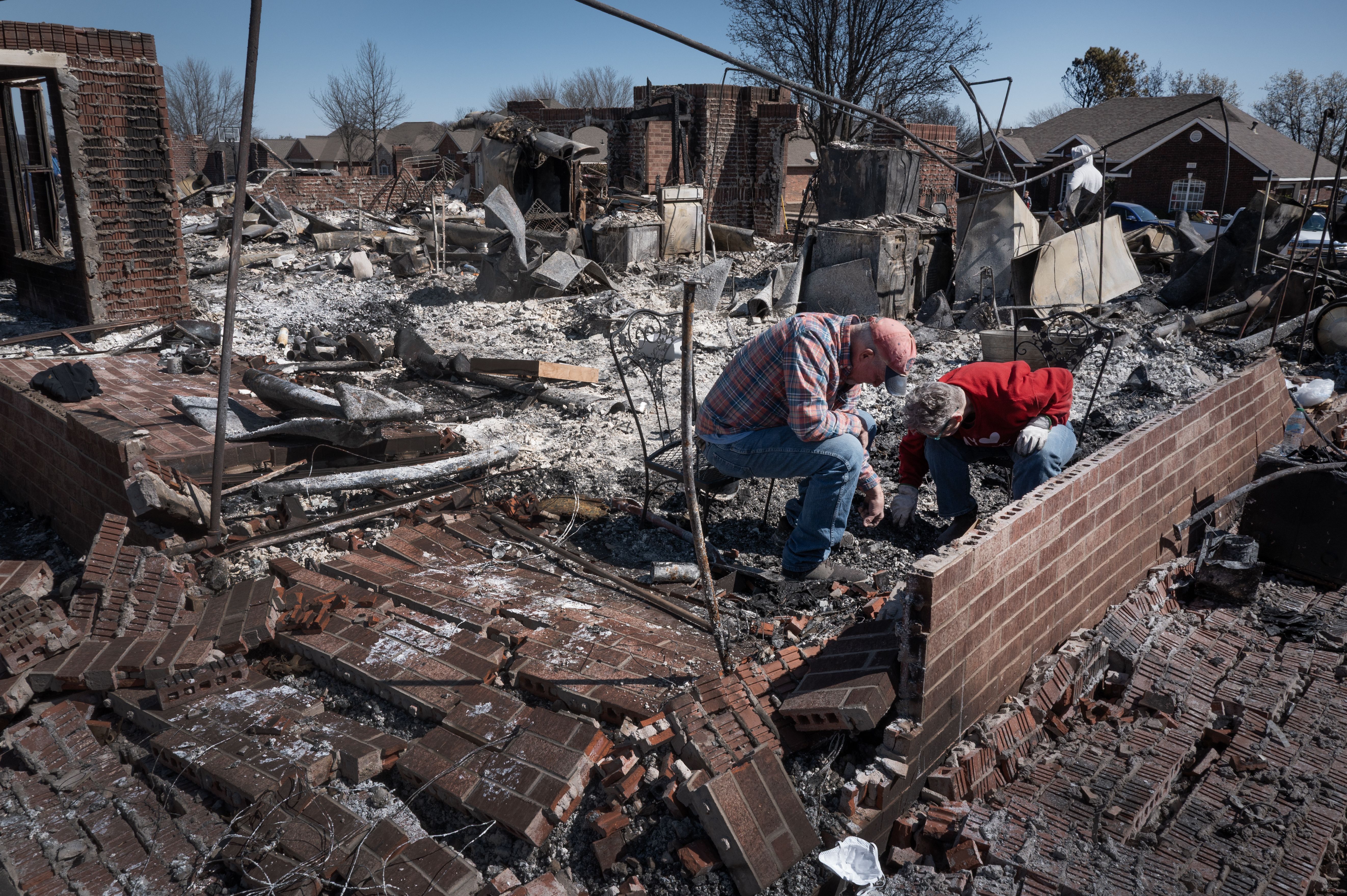 Family members help a homeowner search for salvageable possessions after their home was destroyed during Friday's wildfires on March 16, 2025 in Stillwater, Oklahoma. 