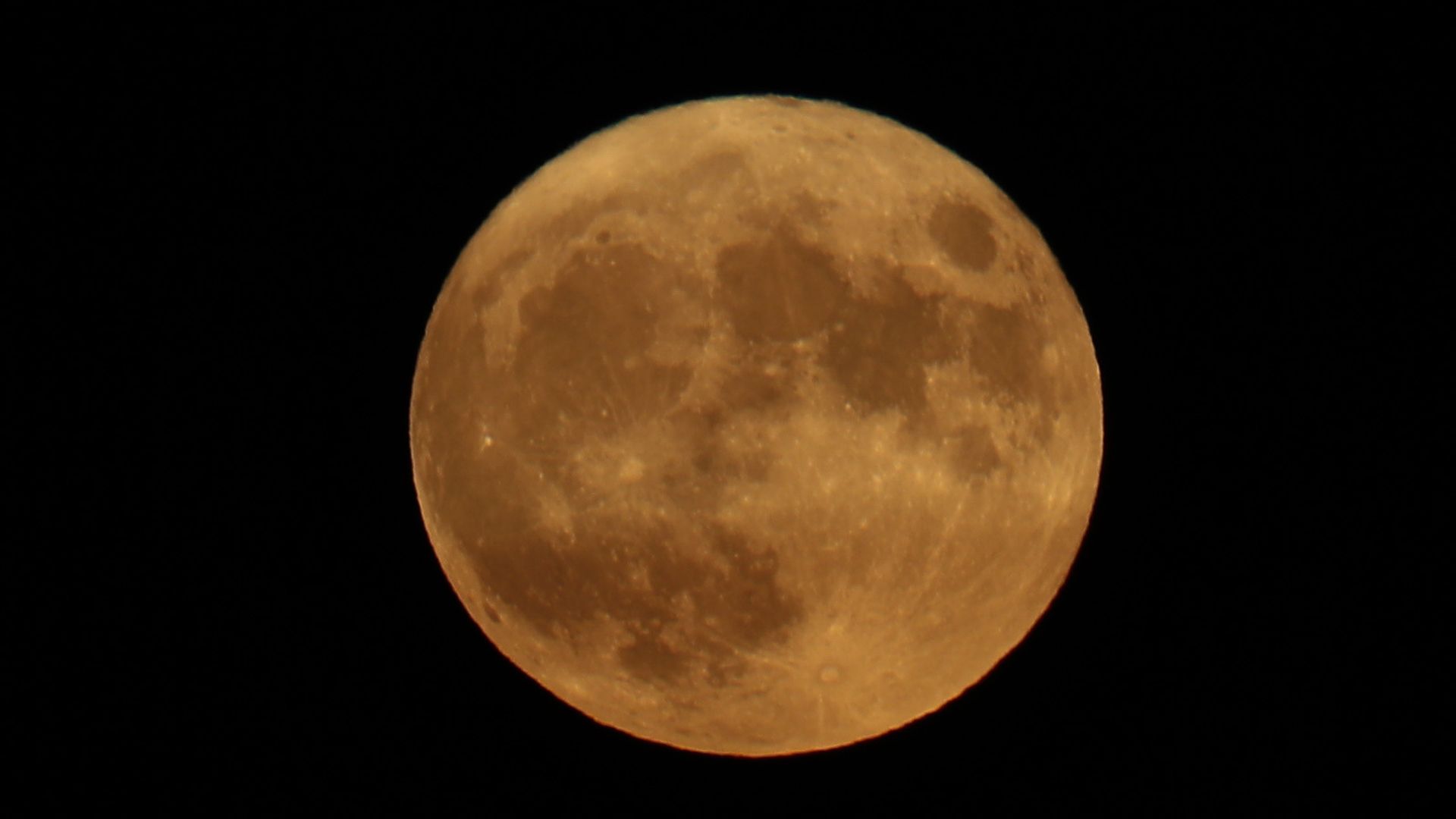 A full moon against a black sky.