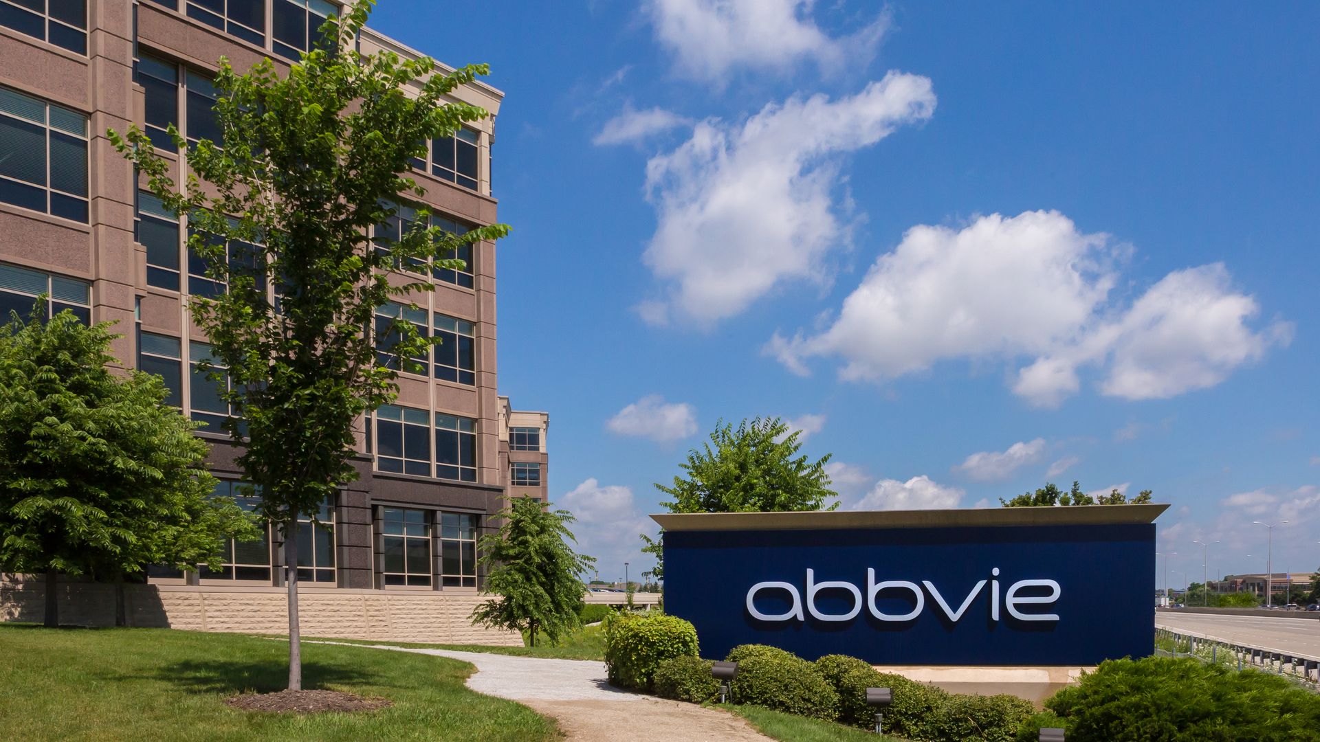 A blue AbbVie sign outside of its headquarters building.