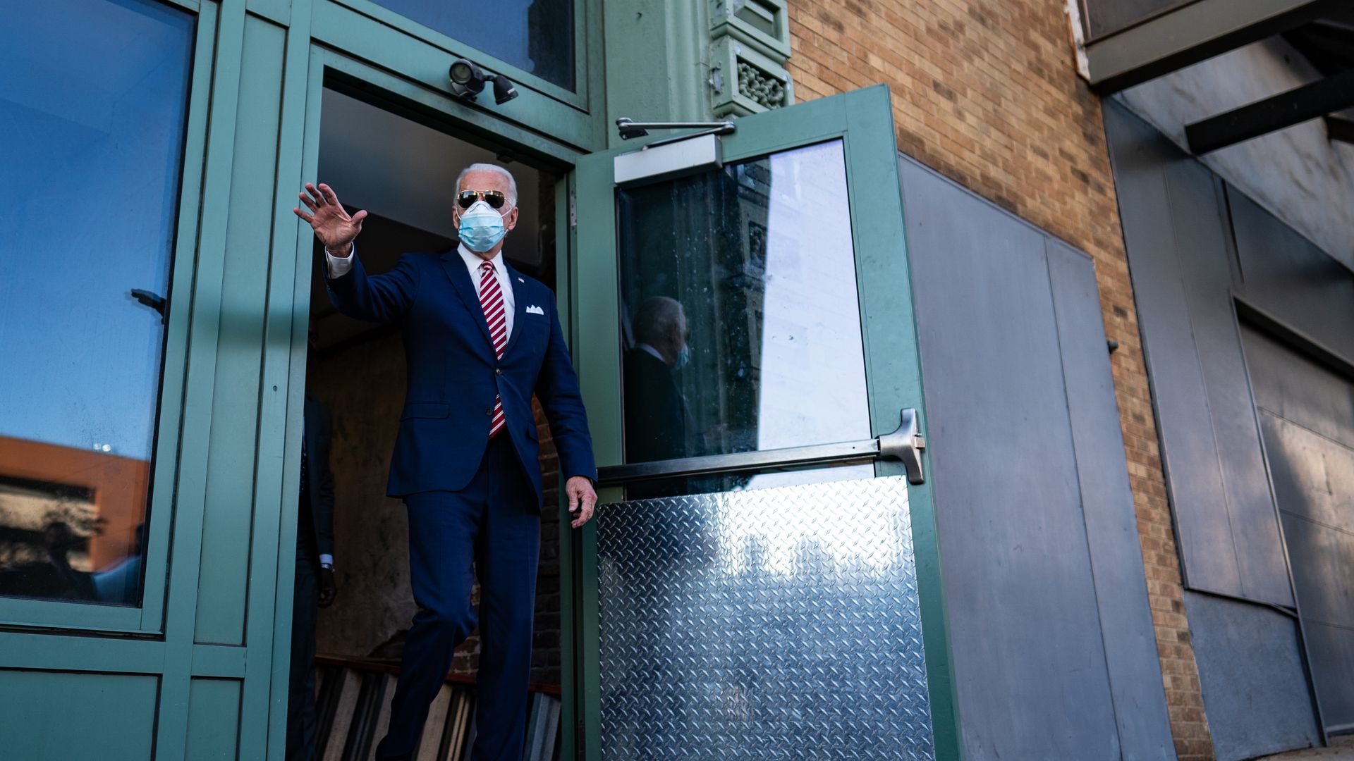 Joe Biden walks out of a building. 