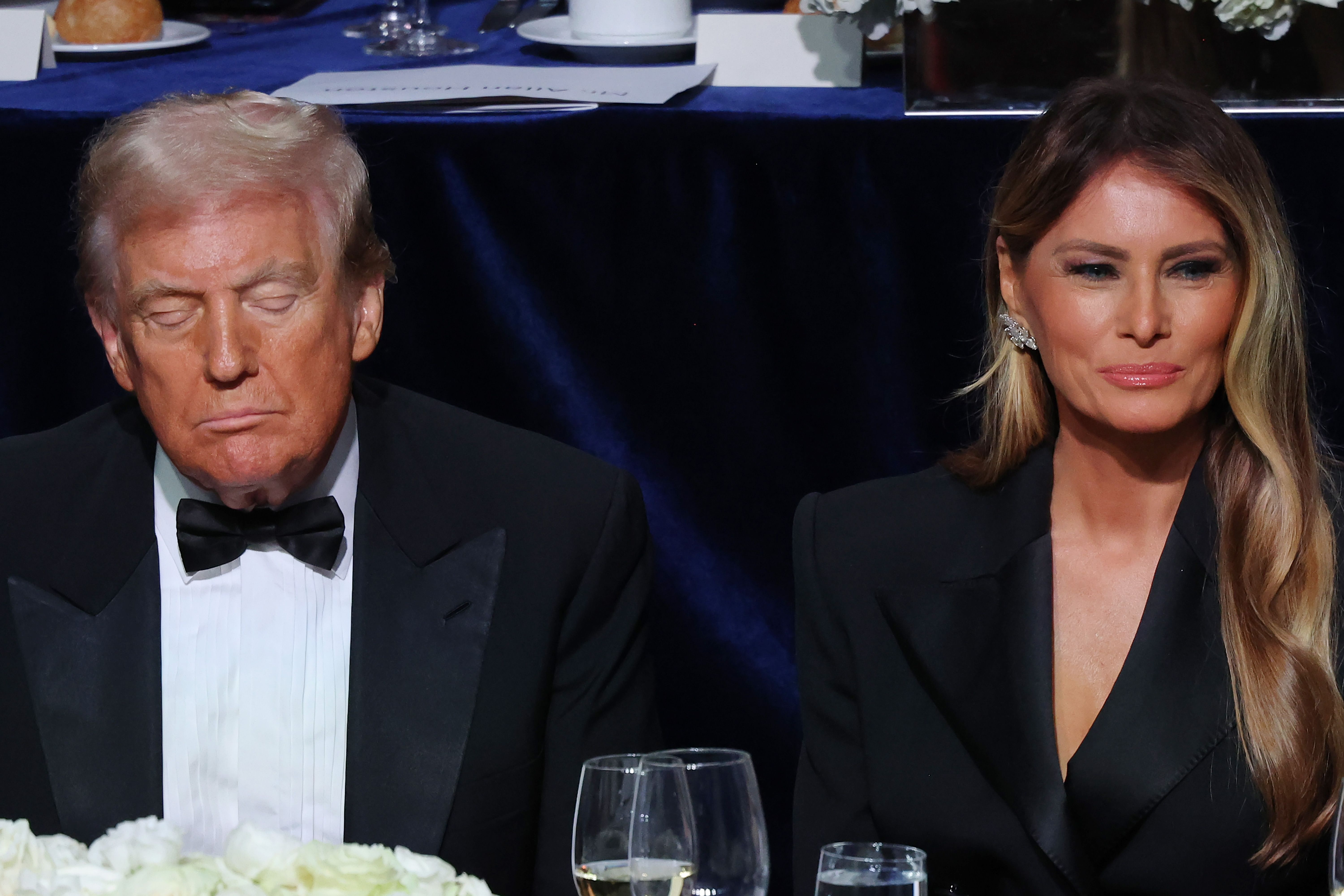 Former President Trump's eyes are closed as he sits with a smiling former first lady Melania Trump attend the annual Alfred E. Smith Foundation Dinner at the New York Hilton Midtown on October 17, 2024 in New York City. 