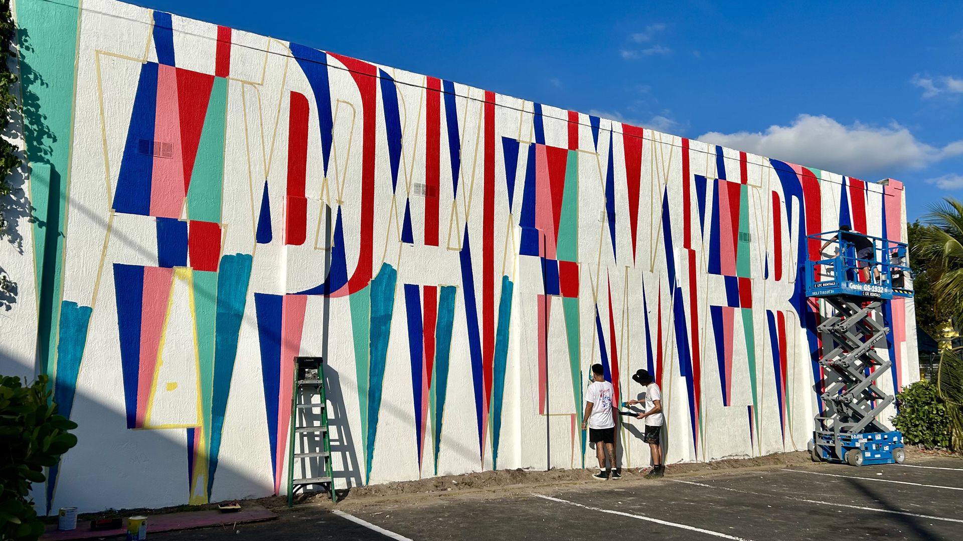 Artist work on a mural spelling out "Ephemeral." 