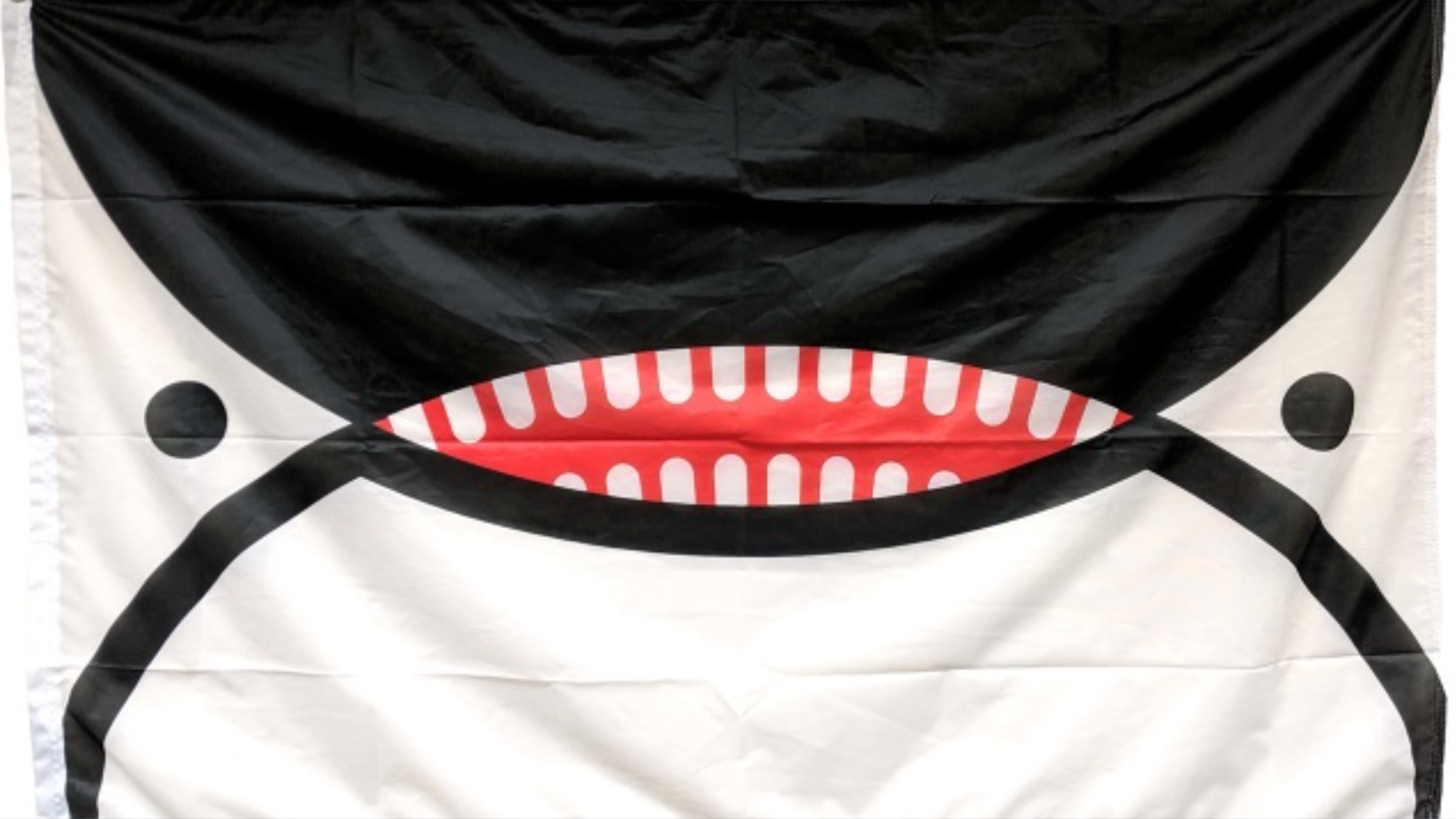 A black, white and red flag with an orca face.