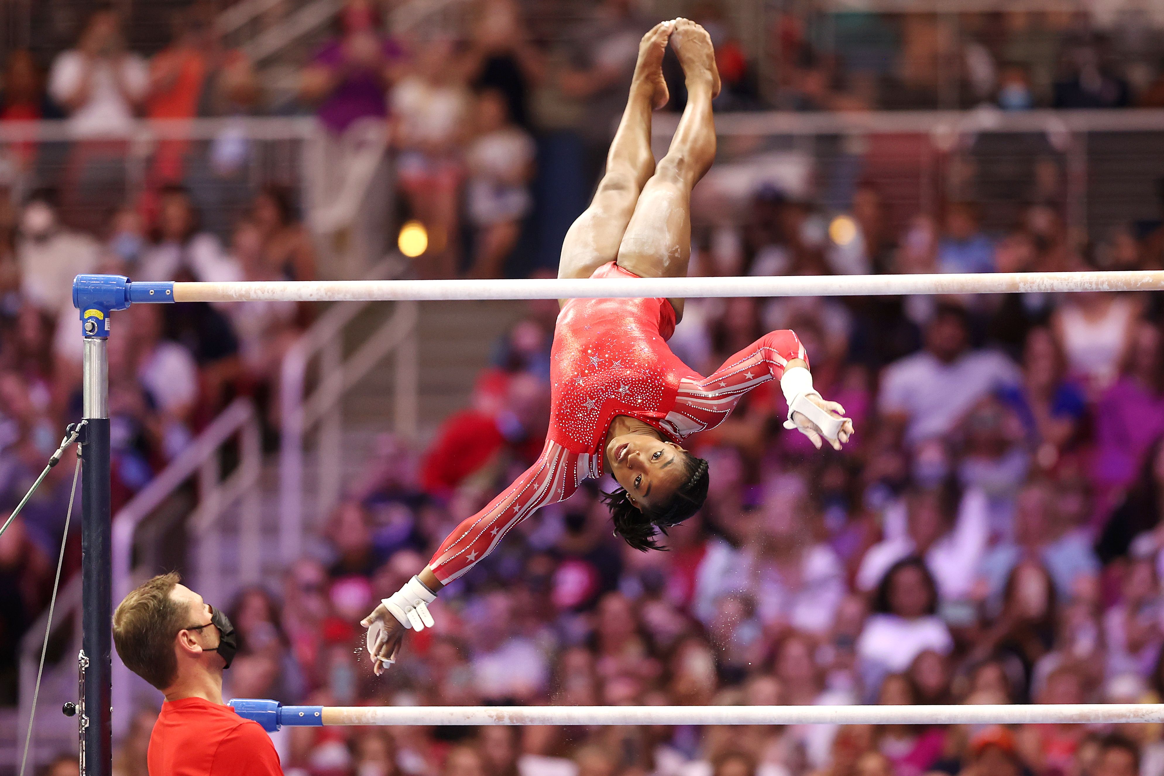 Simone Biles flipping over the uneven bars at the 2021 Olympic trials