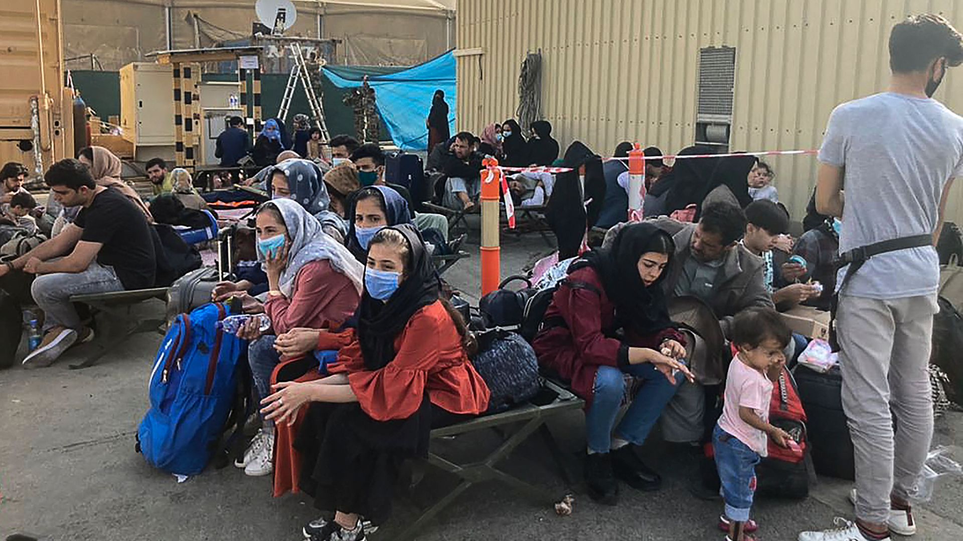 People wait to be evacuated from Afghanistan at the airport in Kabul on August 18