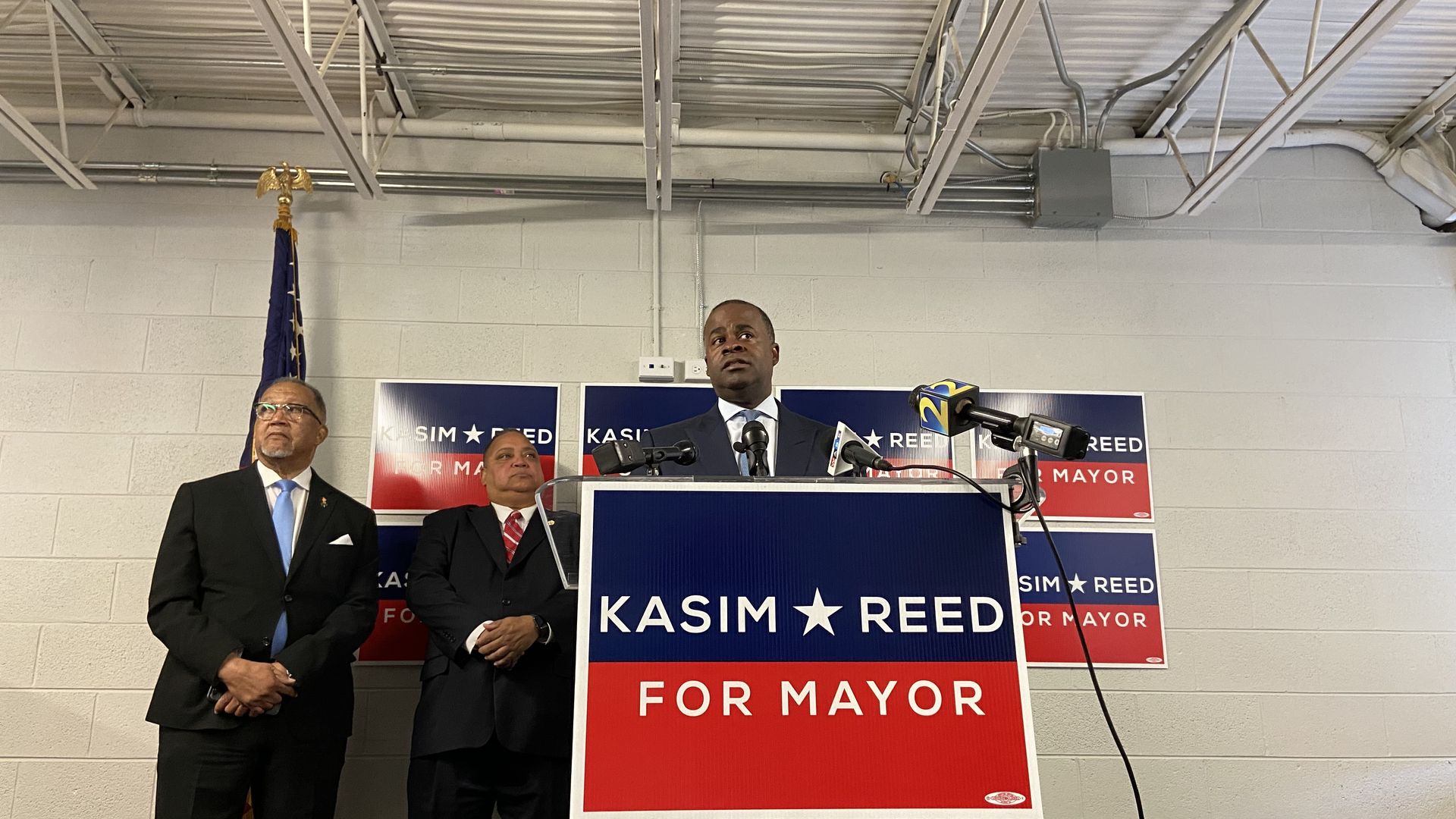 Kasim Reed stands at a podium in front of campaign signs