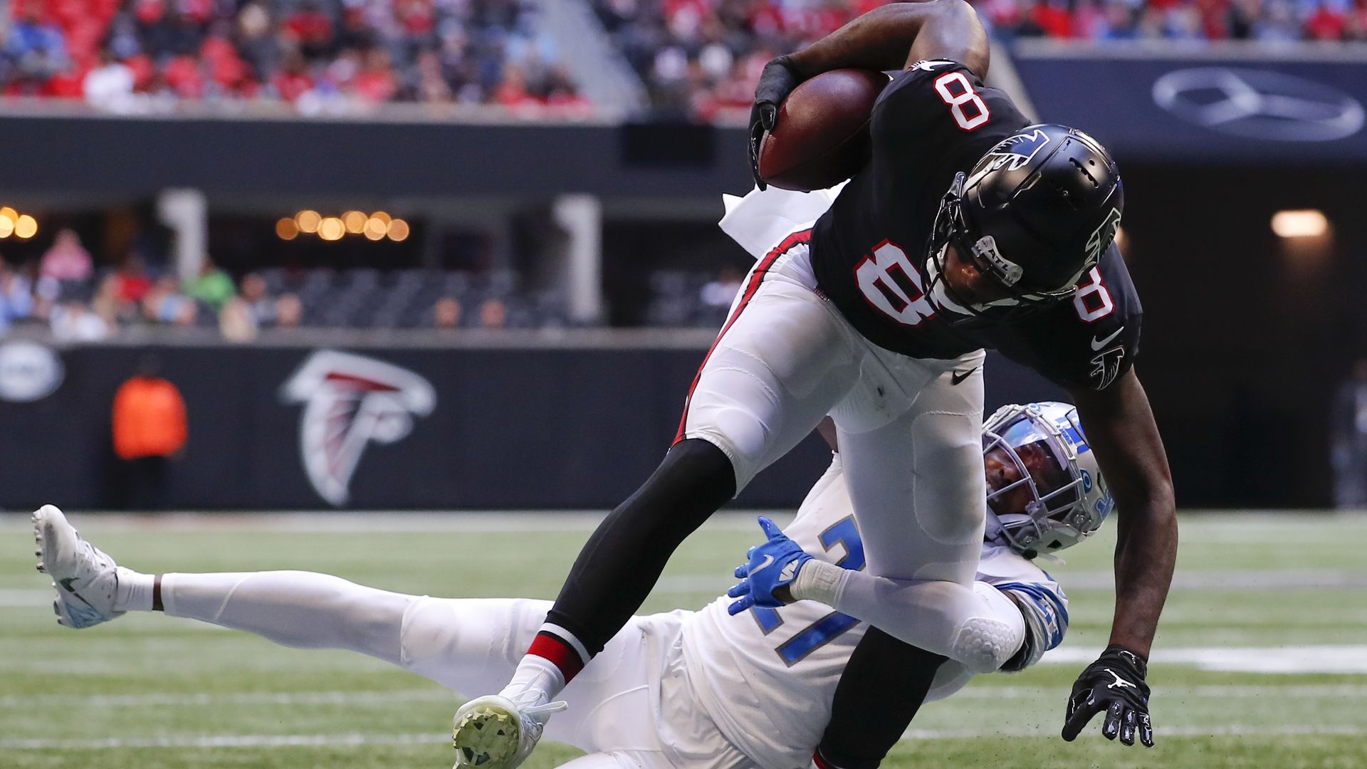 Kyle Pitts #8 of the Atlanta Falcons is tackled by Tracy Walker III #21 of the Detroit Lions in the first half at Mercedes-Benz Stadium on December 26, 2021 in Atlanta, Georgia. 