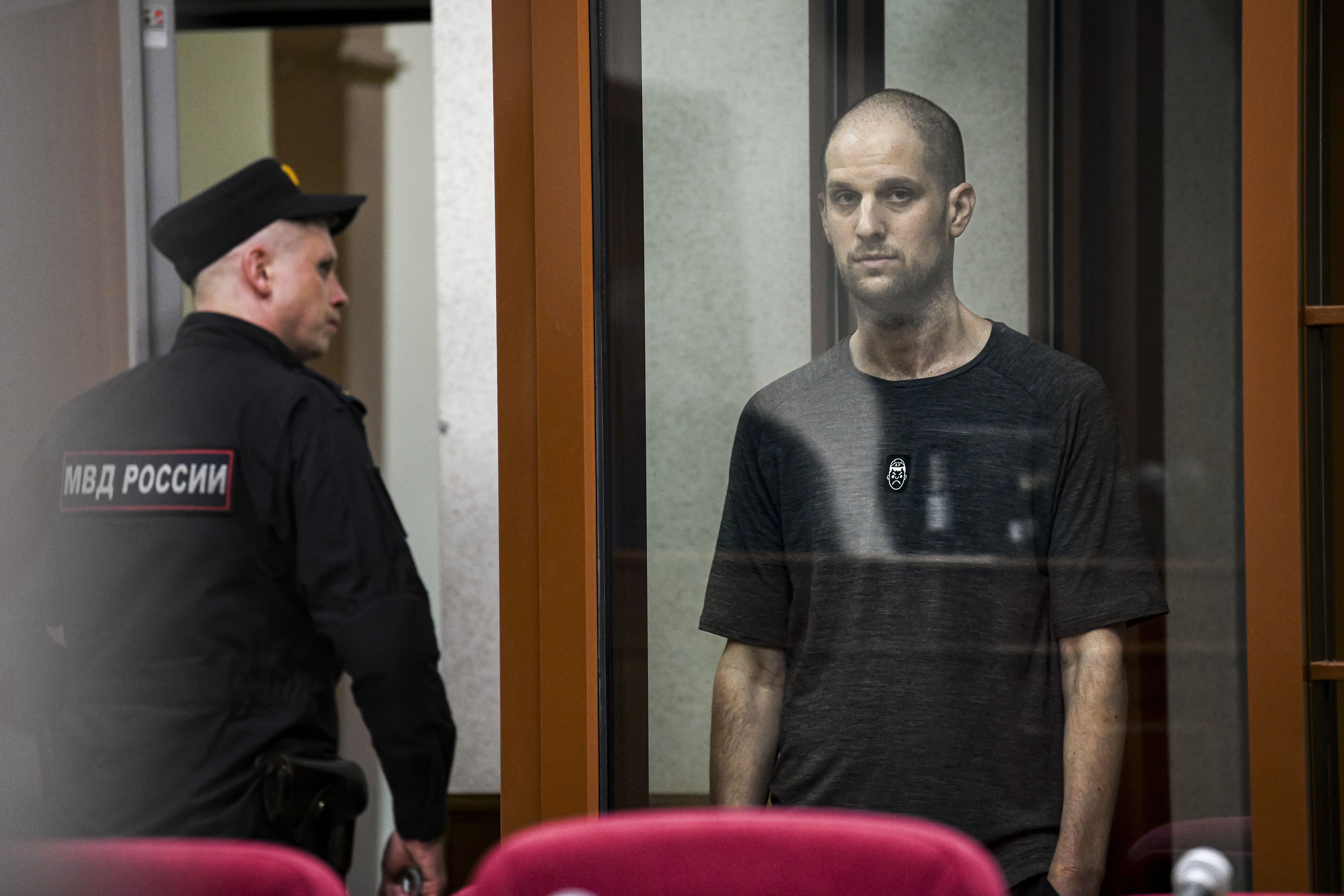 Wall Street Journal reporter Evan Gershkovich stands listening to the verdict in a glass cage of a courtroom inside the building of "Palace of justice," in Yekaterinburg, Russia, on Friday, July 19, 2024. A Russian court convicted Gershkovich on espionage charges that his employer and the U.S. have 