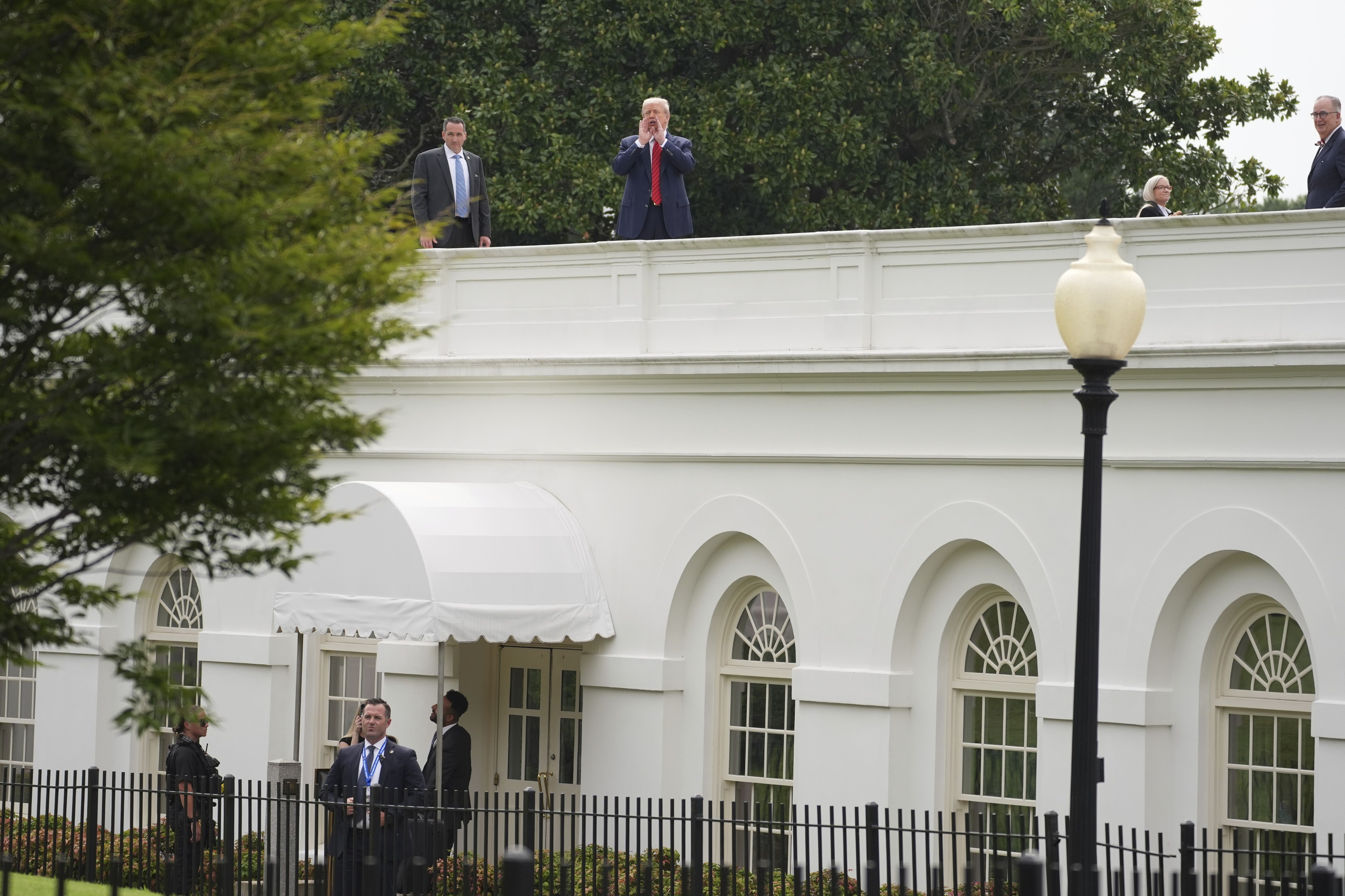 President Trump shouts to reporters as he surveys the roof above the White House colonnade that goes to the West Wing.