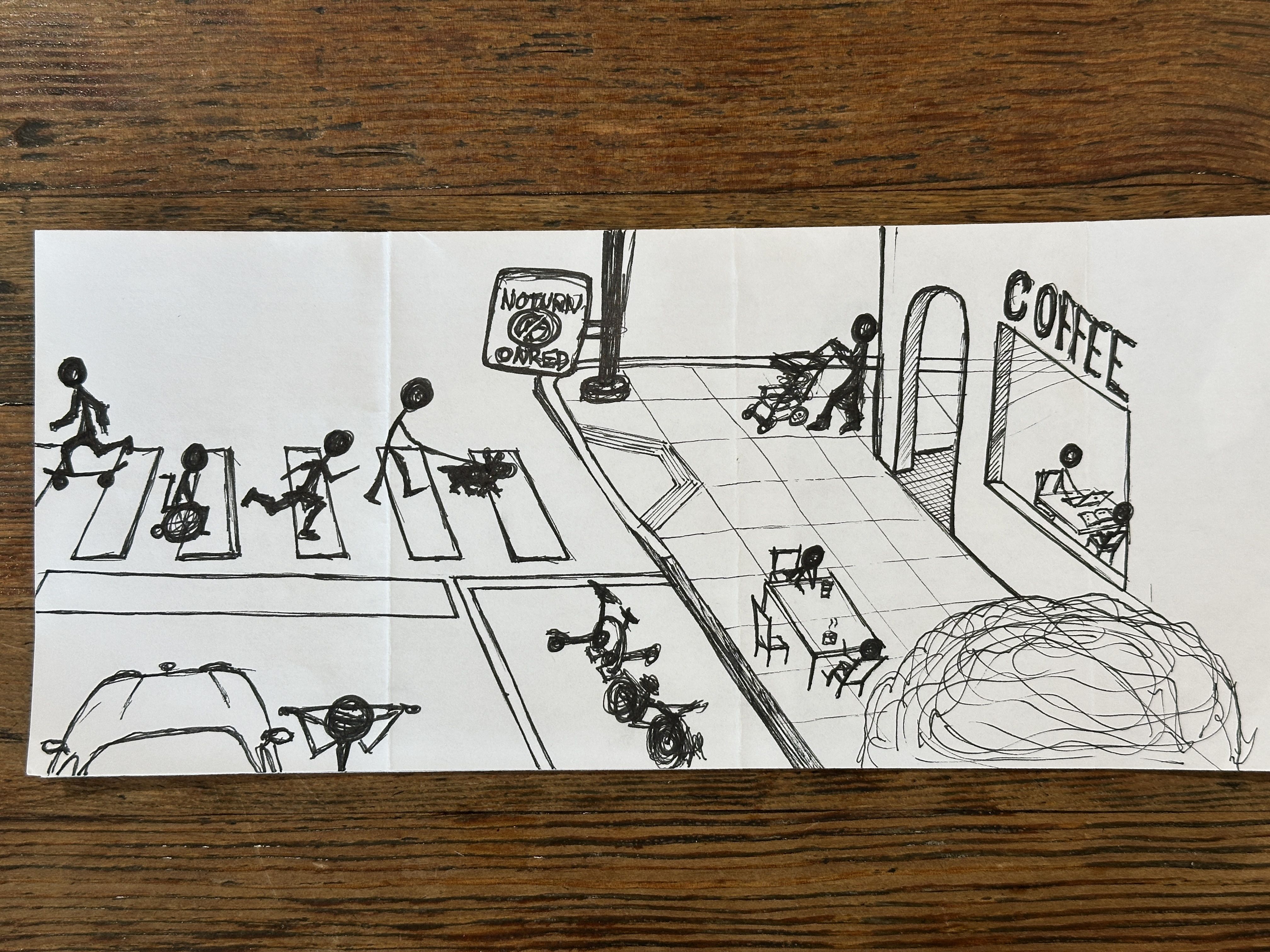 Black line drawing of a busy city street: pedestrians crosswalks, a cyclist and a wheelchair user, a stroller, a coffee shop labeled COFFEE, and a "NOT NORMAL ORDER" sign near a ramp.