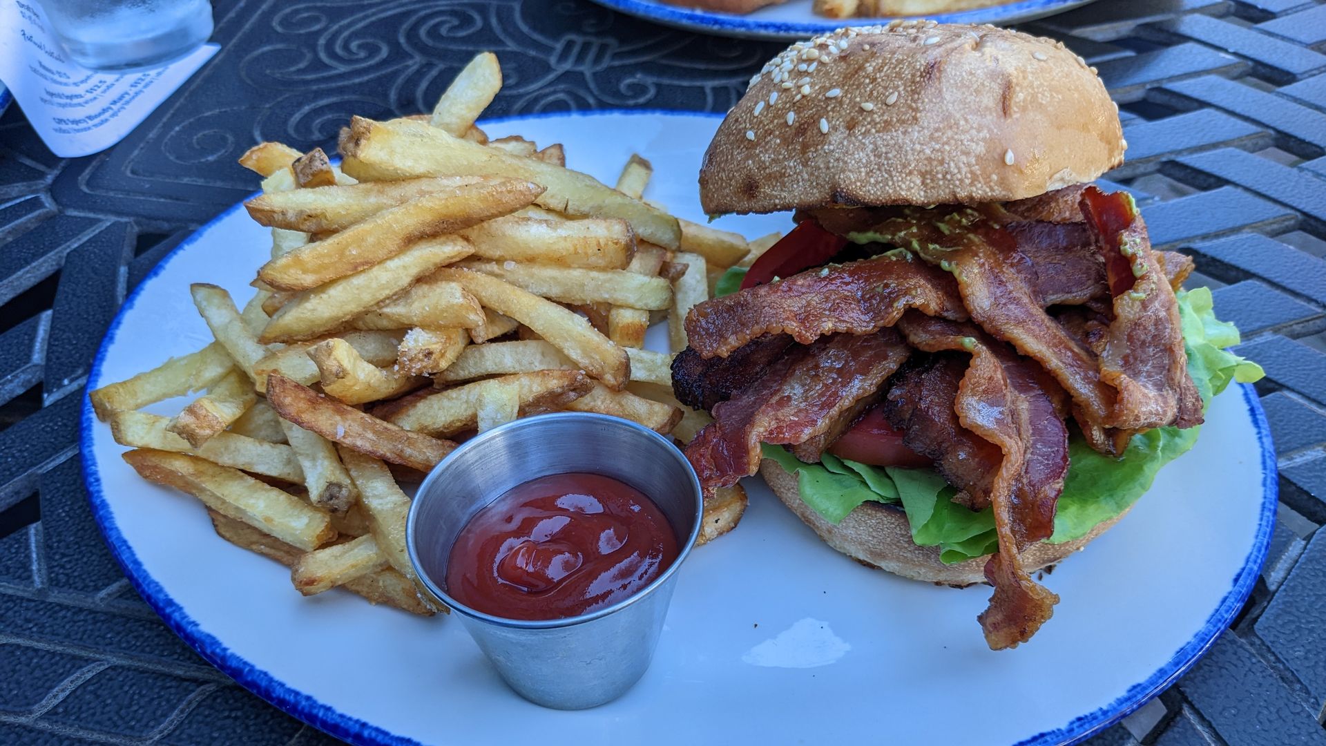 A BLT sandwich plated with a side of french fries