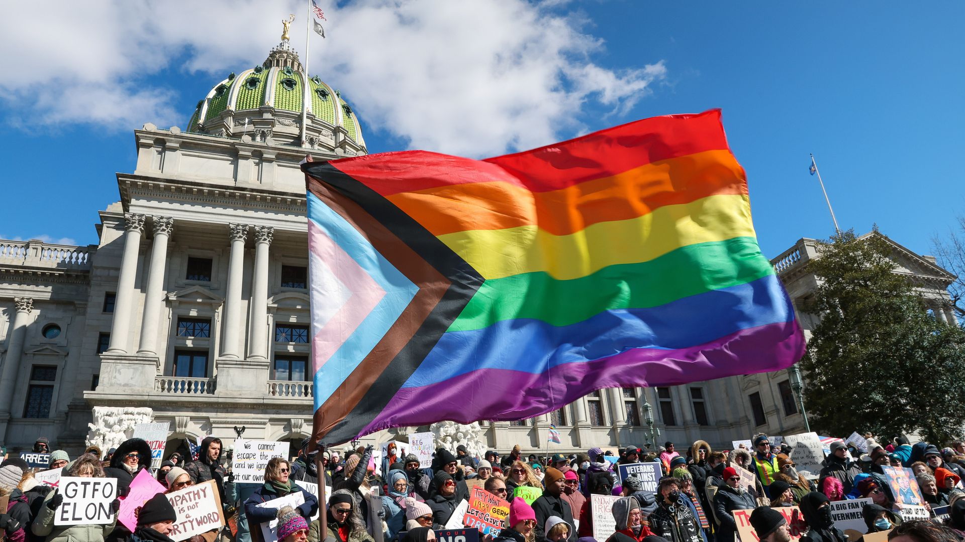 2025/02/17: A protester waves a Pride flag during the demonstration outside the Pennsylvania Capitol.