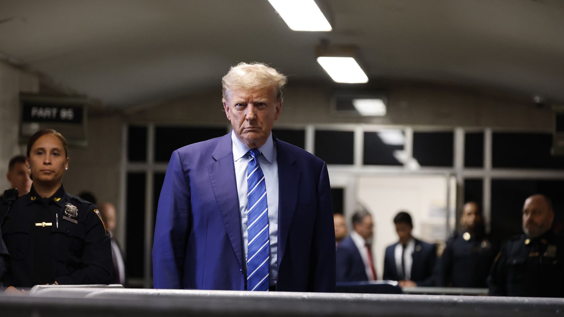 Trump listens to reporters' questions outside a Manhattan courthouse.