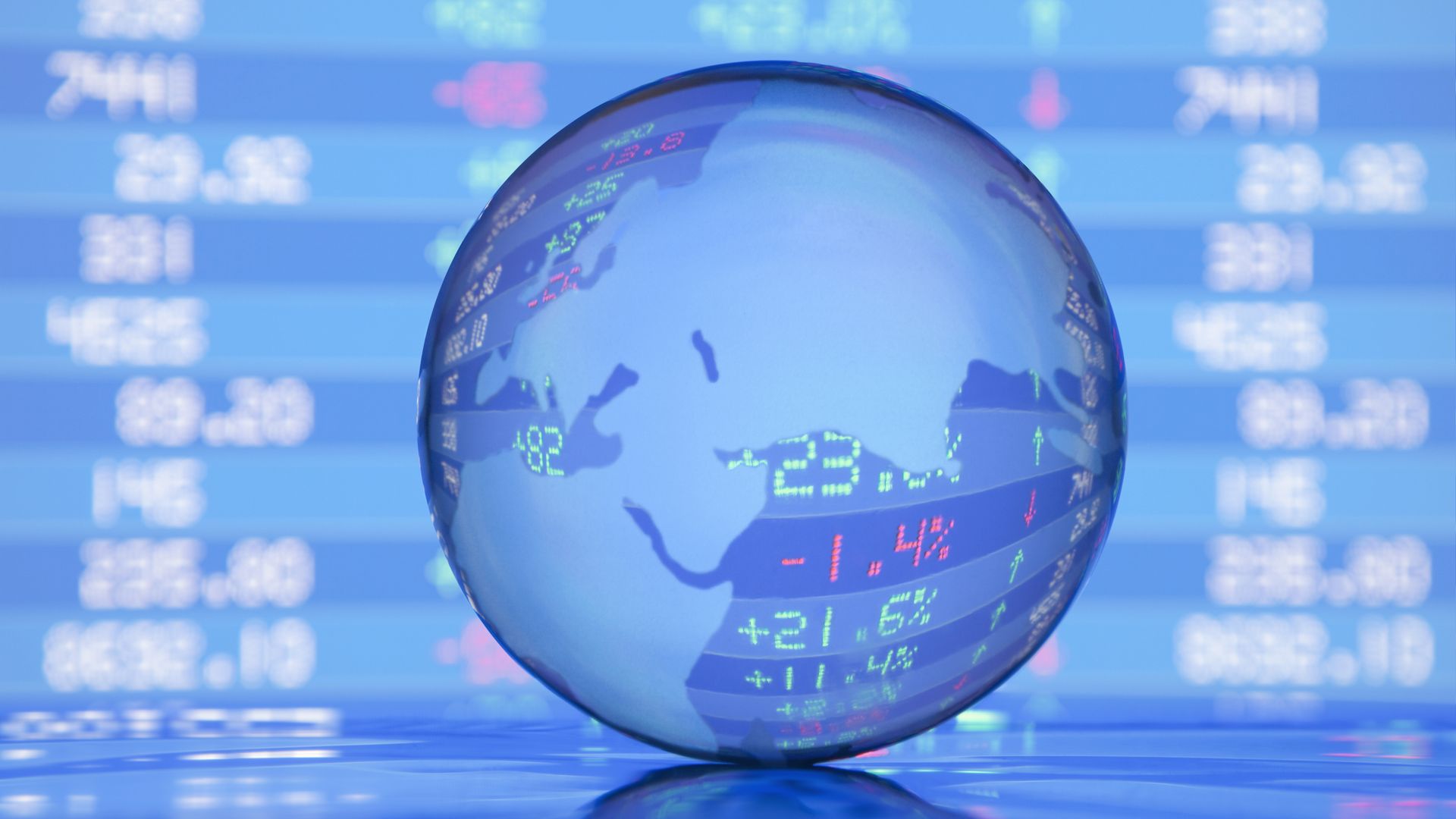 A globe in front of stock market listings