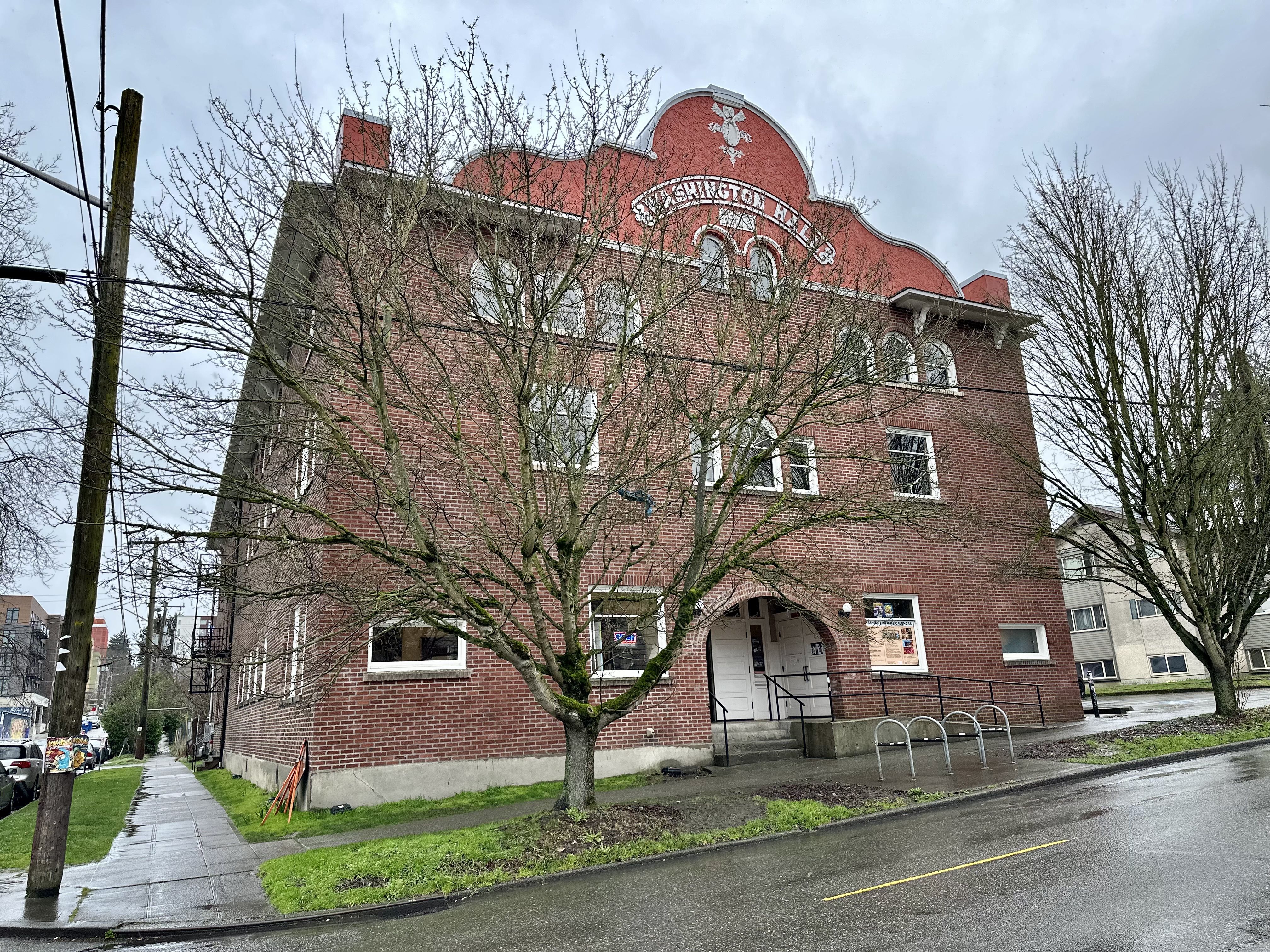 A brick building that says "Washington Hall" and the building's founding date of 1908.