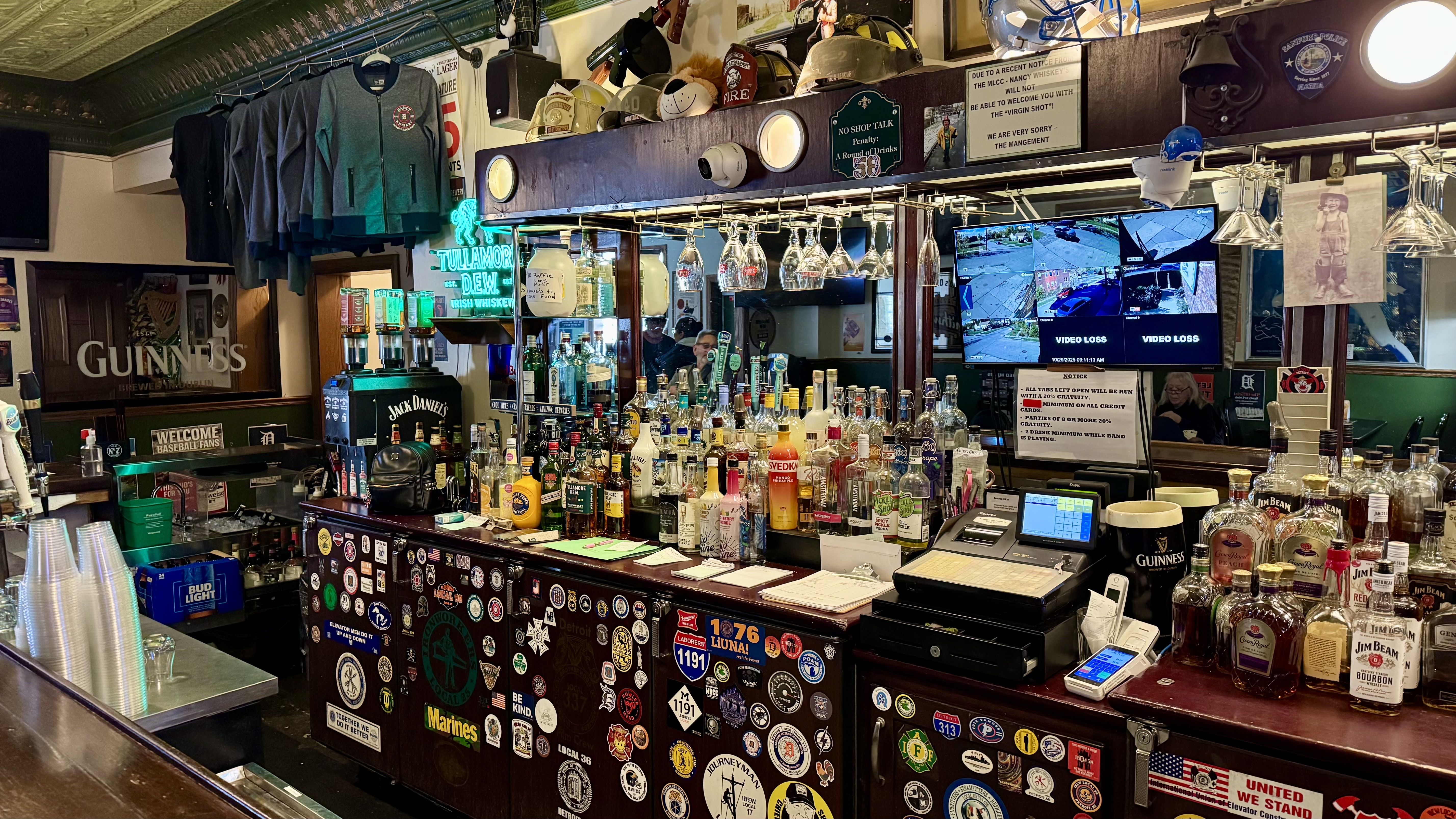 The bar inside Nancy Whiskey is riddled with bottles, stickers, and patches. It looks lovingly cluttered