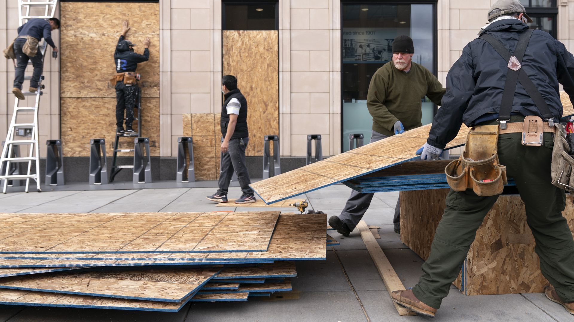 Workers board up Walgreens on U Street NW in D.C. yesterday.